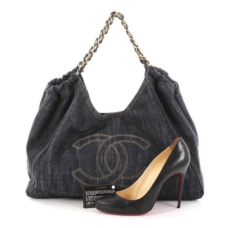 This authentic Chanel Coco Cabas Denim Large is an easy-to-carry tote made for everyday excursions. Crafted in blue denim, this roomy hobo features an oversized stitched CC frontal logo, ruched detailing, woven-in denim chain straps, and gold-tone