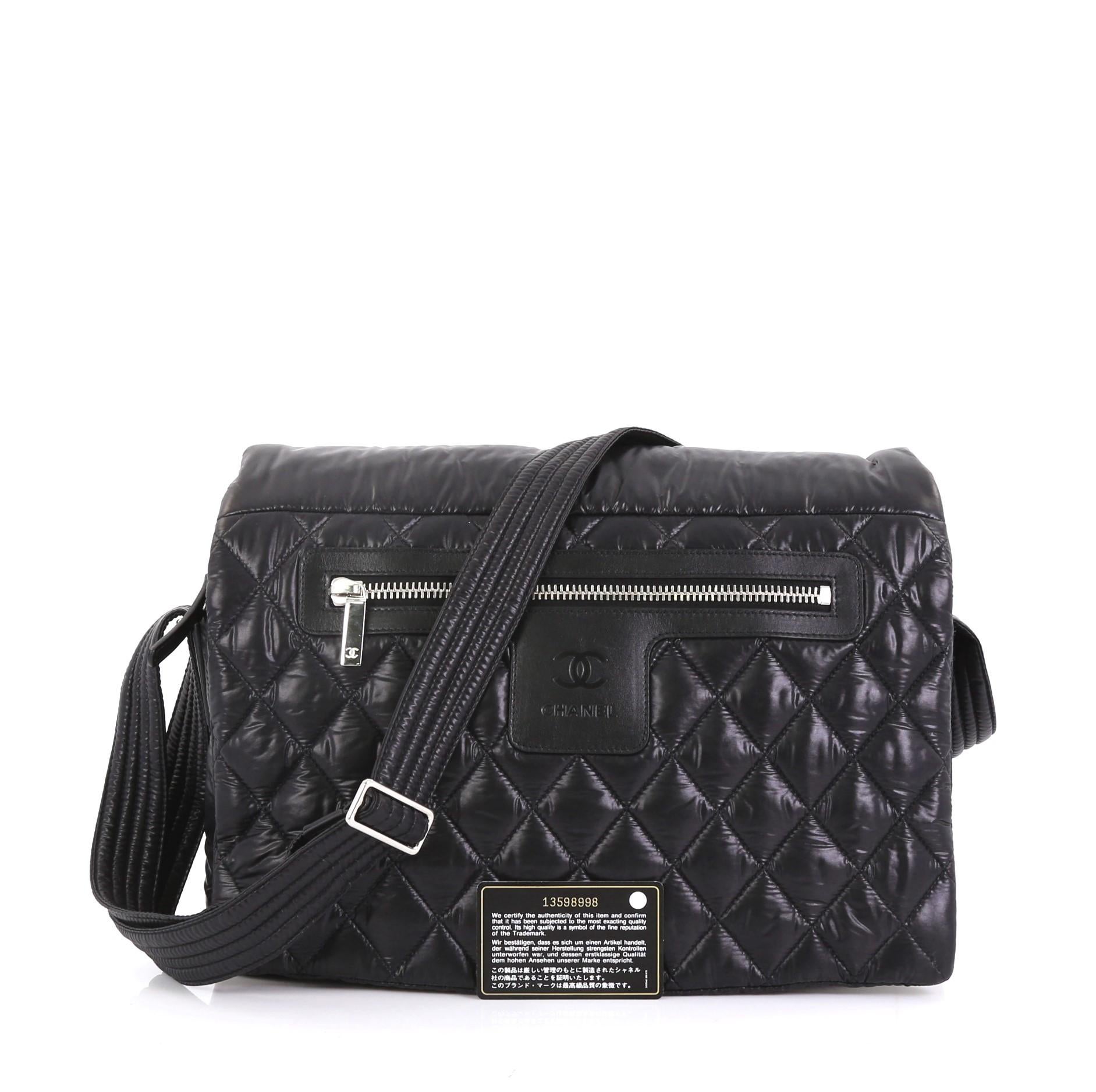 This Chanel Coco Cocoon Messenger Bag Quilted Nylon Large, crafted in black quilted nylon, features a nylon quilted strap, exterior front zip pocket, and silver-tone hardware. Its flap and zip closure opens to a burgundy nylon interior with zip