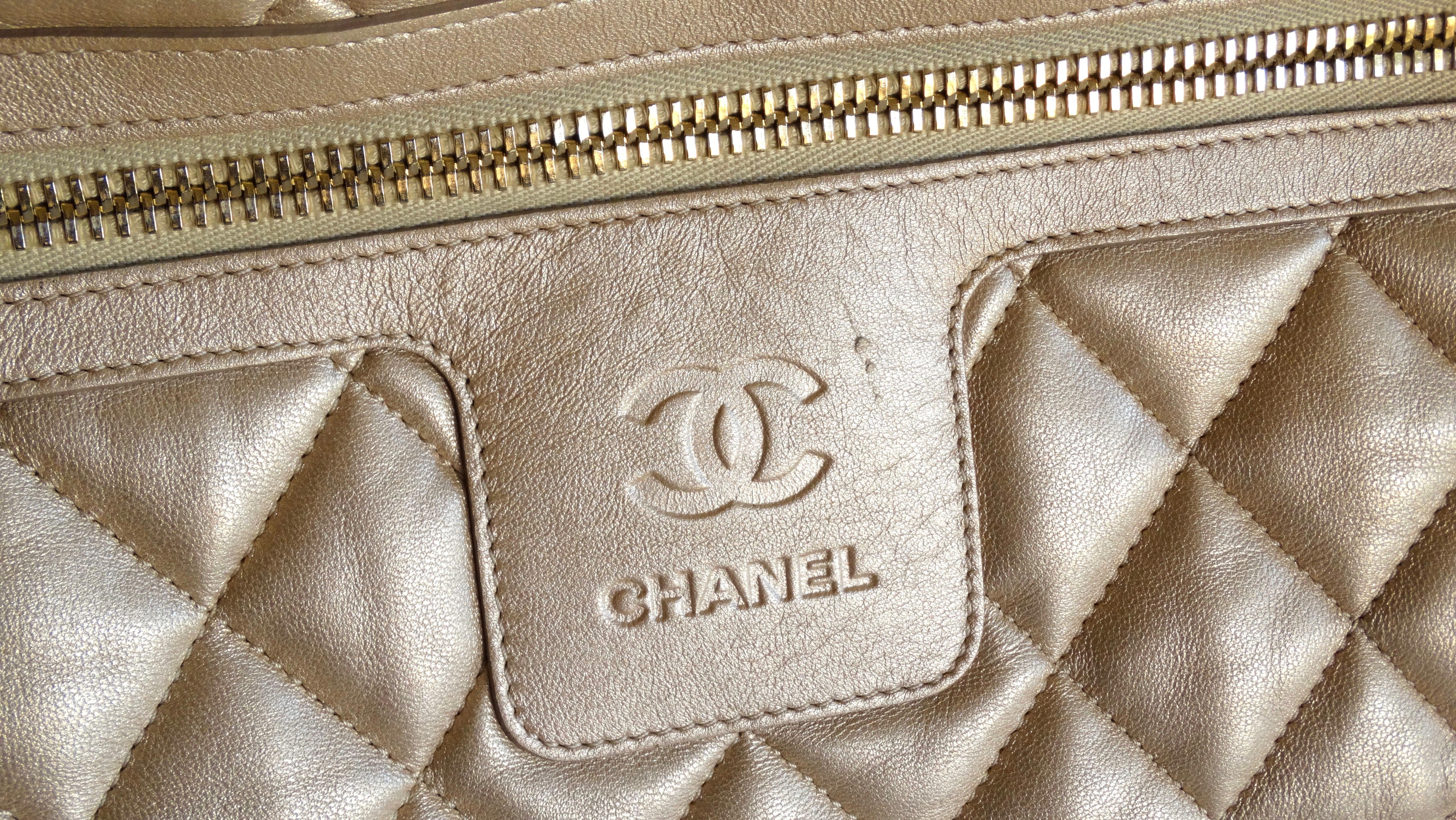 Show off with this adorable Chanel tote! Circa 2009, this large tote is crafted from shimmery champange  gold leather and features puffed quilted stitching. Includes gold hardware, a CC embossed bottom, puffy dual top handles, a zipper pocket on the