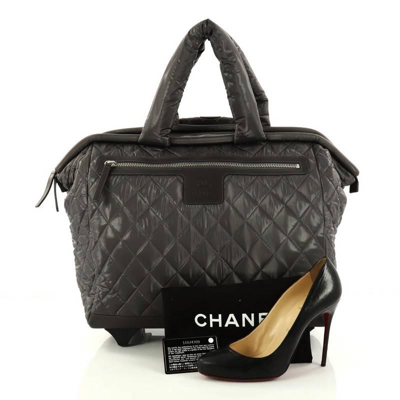 This authentic Chanel Coco Cocoon Rolling Trolley Quilted Nylon is a highly sought-after travel piece from Karl Lagerfeld's fun and chic Coco Cocoon line. Crafted from signature grey quilted nylon with leather panels, this sporty yet chic trolley