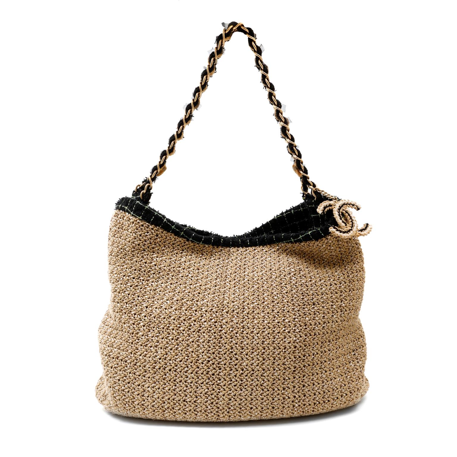 This authentic Chanel Coco Country Seagrass Camellia Bag is in excellent condition.  The casual style is embellished with chic Chanel design elements.  
Neutral woven raffia large bag has black boucle tweed camellia flower embellishment.  Single