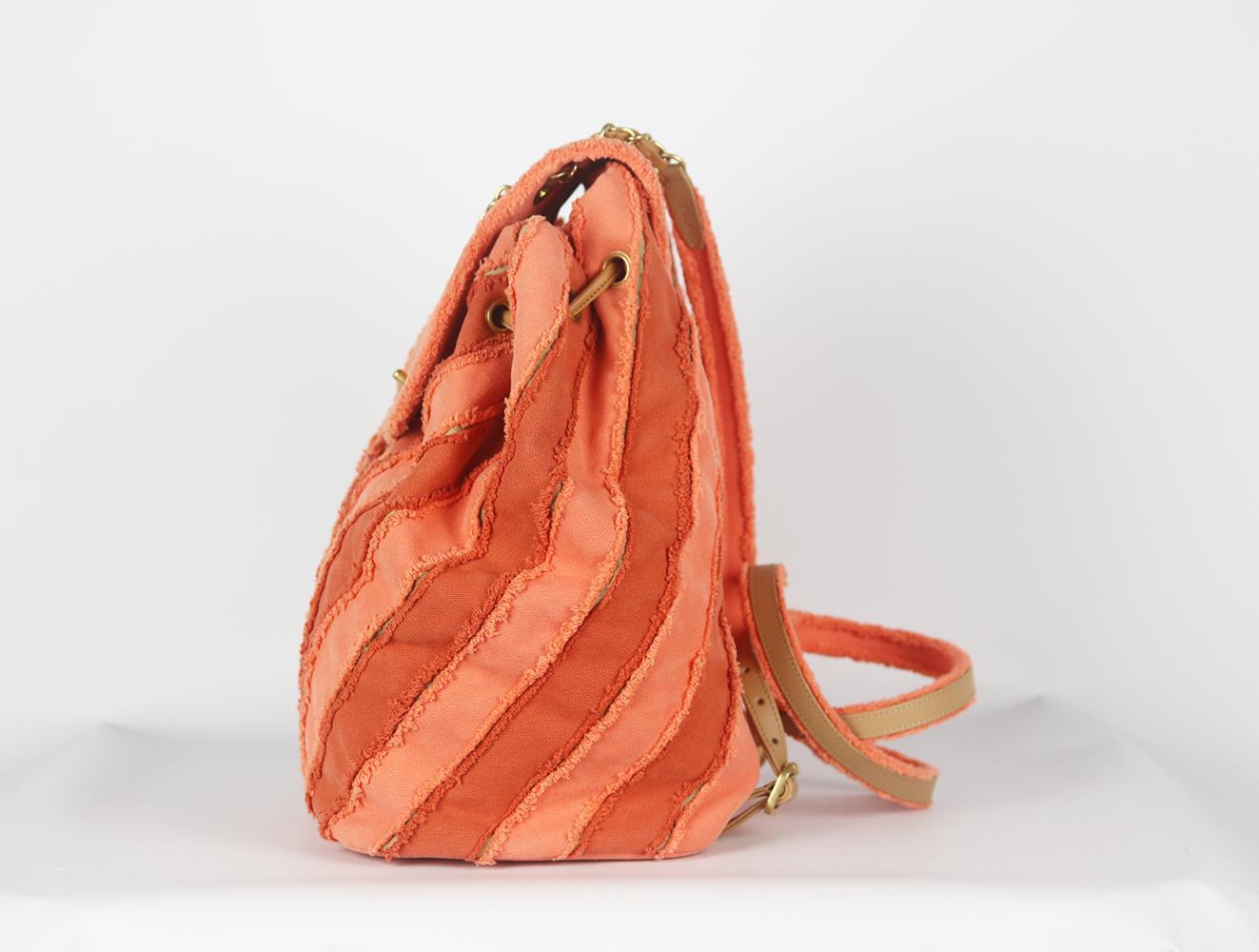 <ul>
<li>Confectionné en Italie, ce magnifique sac à dos Chanel Coco Cuba Chevron a été réalisé en toile orange et cuir beige à l'extérieur et en tissu gris à l'intérieur. Il est décoré du logo Chanel en or vieilli sur le devant et se termine par