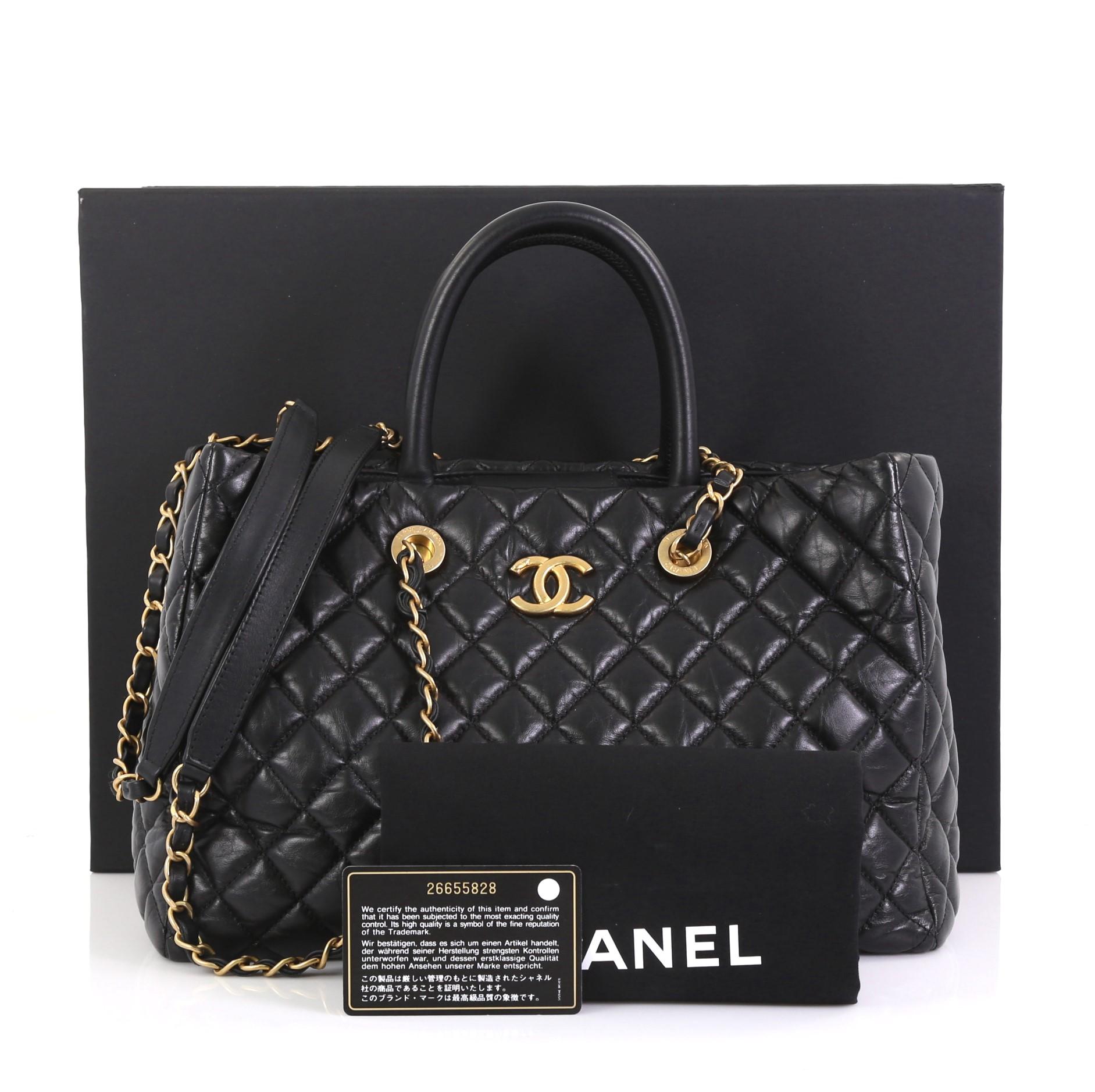 Diese Chanel Coco Handle Shopping Tote Quilted Aged Calfskin Large:: gefertigt aus schwarzem:: gestepptem:: gealtertem Kalbsleder:: verfügt über doppelt gerollte Ledergriffe:: eingewebte Lederkettengliederriemen mit Lederpolstern:: CC-Logo auf der