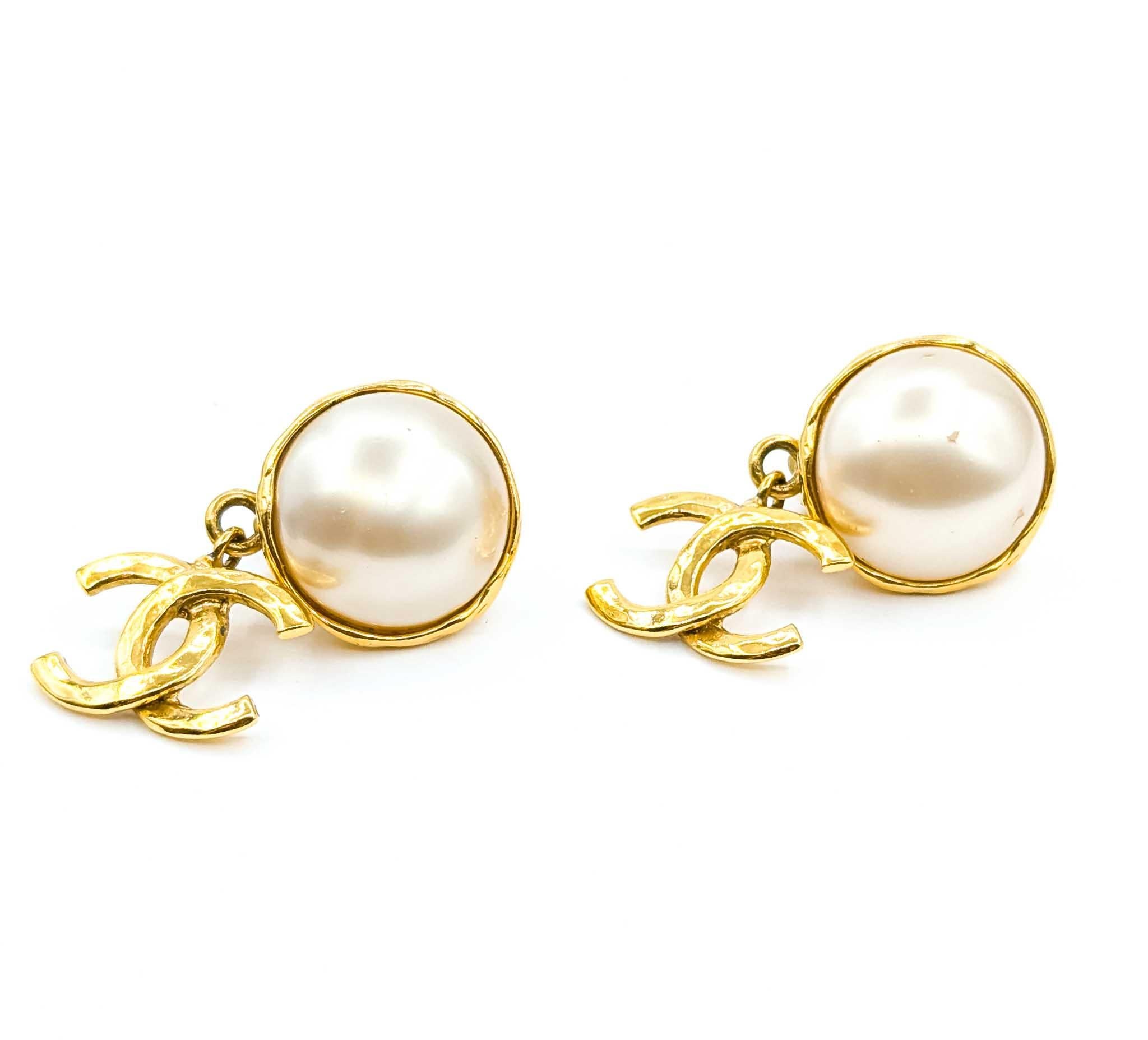 Chanel Coco Mark Dangle Earrings Round Faux Mabe Pearl CC

Step into the world of timeless elegance with these vintage Coco Chanel earrings. Crafted in 1993, these stunning pieces feature round, faux Mabe pearls, delicately suspended from