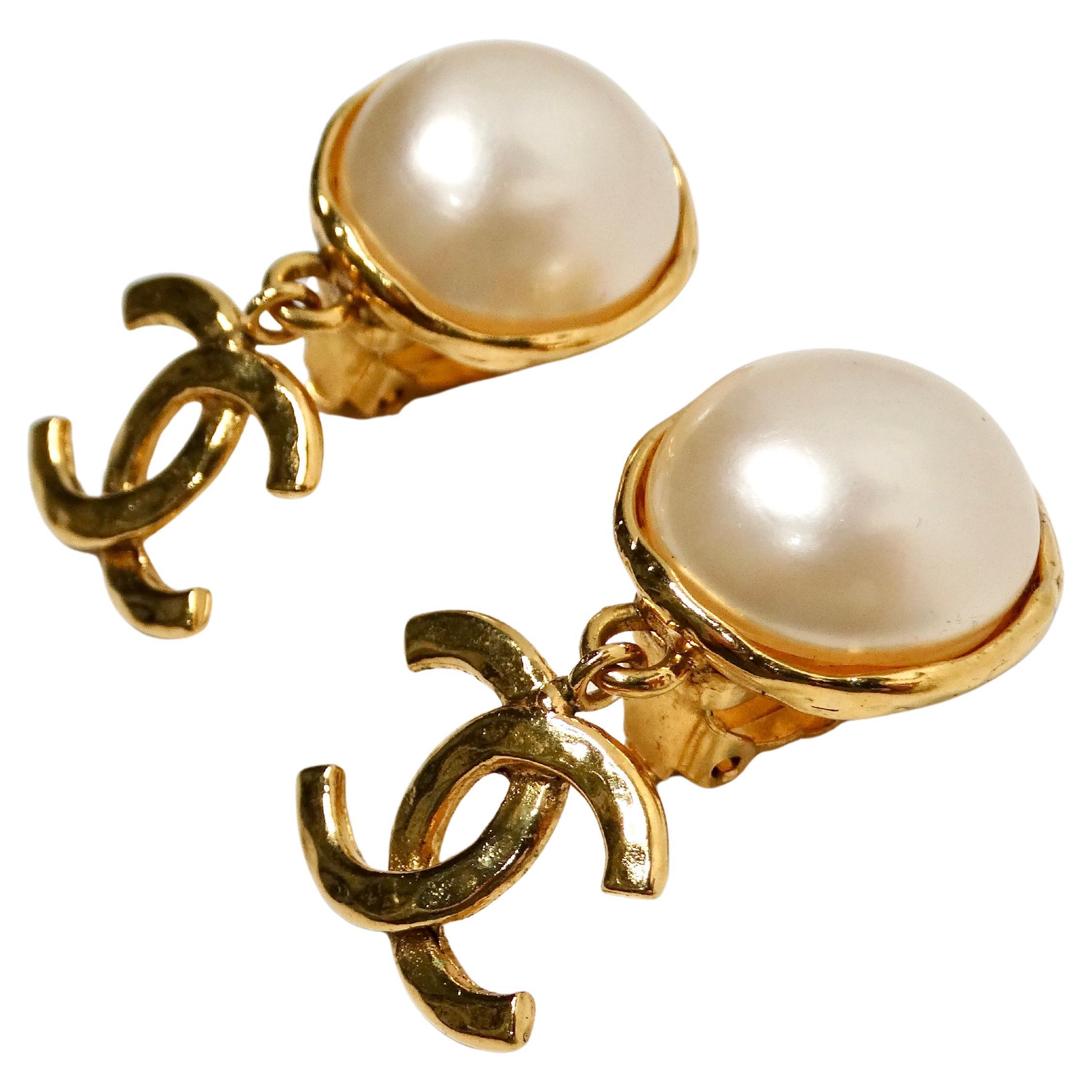 The 1993 Chanel Coco Mark Gold Plated Costume Pearl CC Dangle Earrings are a sophisticated and timeless accessory that exemplifies Chanel’s signature elegance. Featuring a luxurious costume pearl at the top, these earrings are accented with a