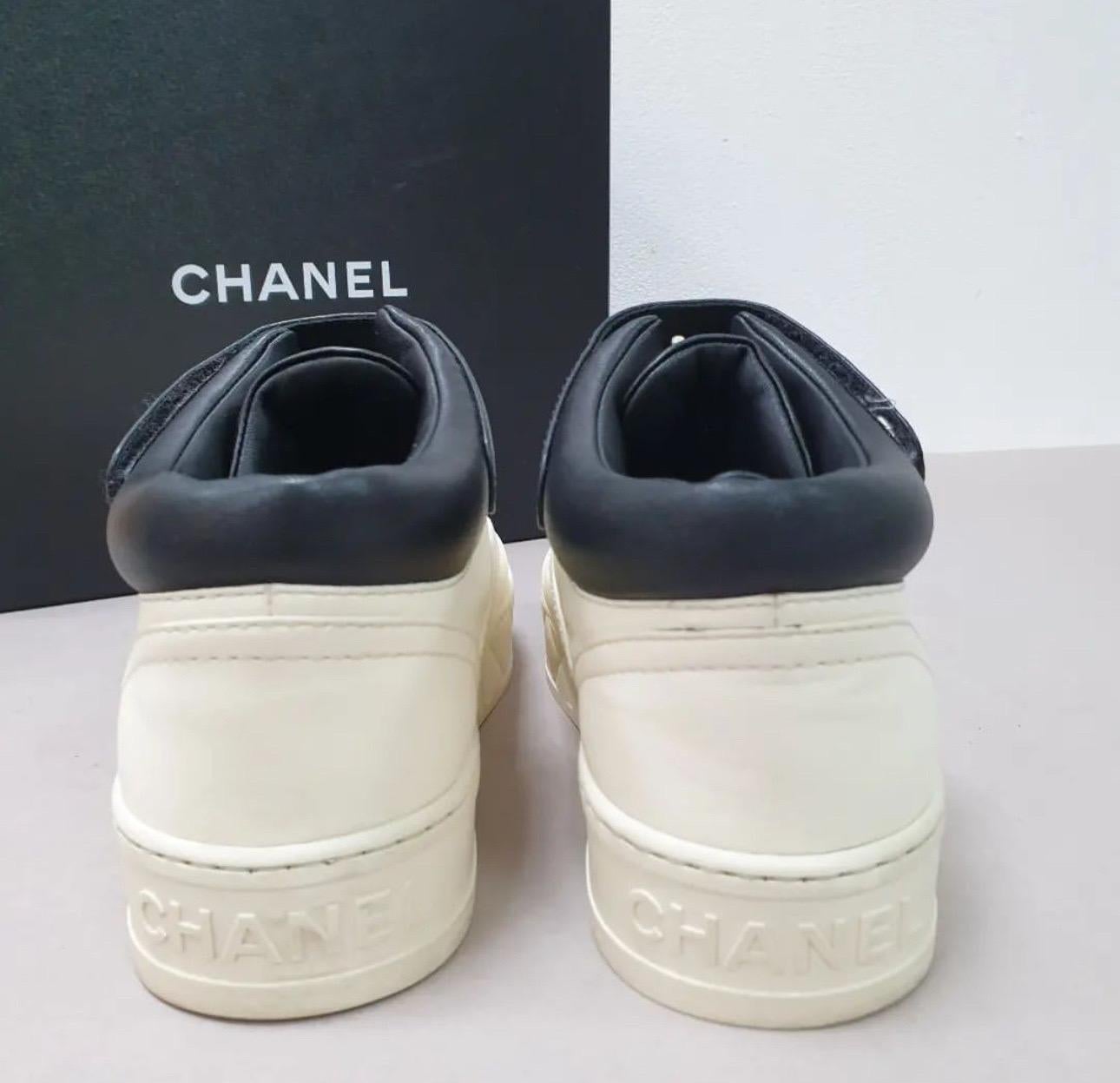 Chanel lambskin leather high-top sneakers in white with a signature metal logo on the black velcro closure, rubber trim, round-toes, platform, and lace-up.
Sz.39
Condition is very good. 
No box. No dust bag.