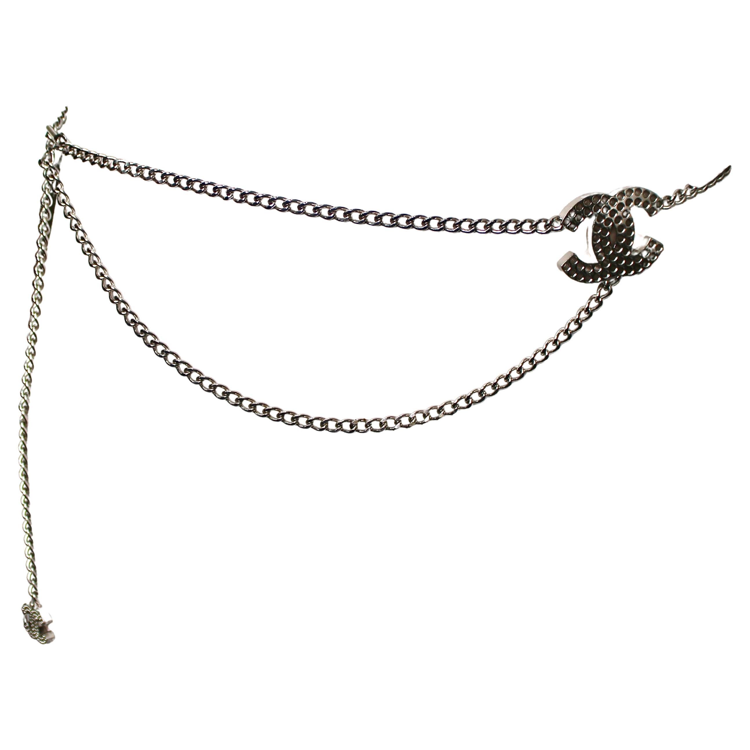 La cintura Chanel Coco Mark Silver-Tone Chain è un accessorio straordinario che incarna lusso e raffinatezza. Realizzata con un'attenzione meticolosa ai dettagli, questa cintura presenta un'elegante catena argentata ornata dall'iconico logo Coco