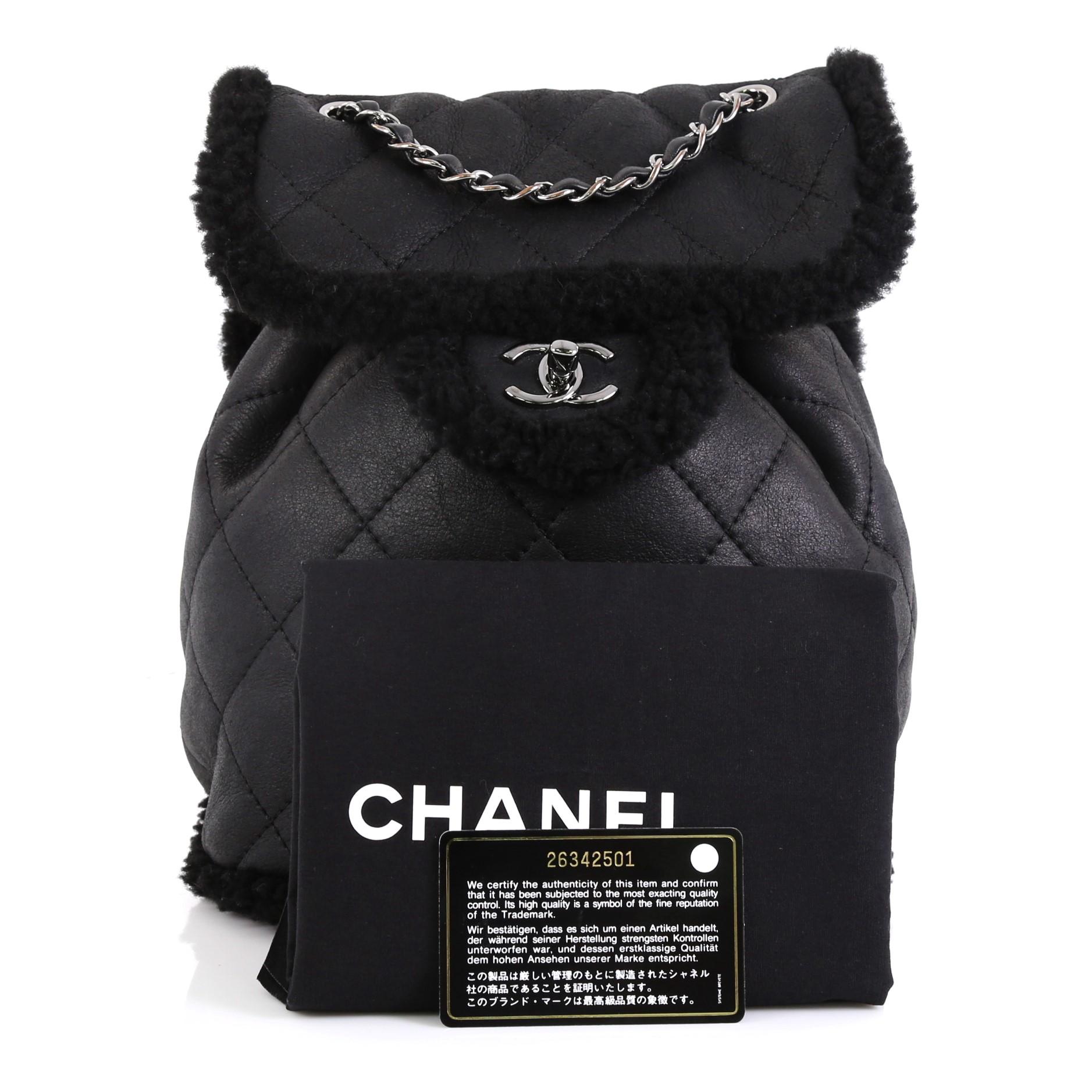 This Chanel Coco Neige Flap Backpack Quilted Lambskin and Shearling Small, crafted in black lambskin leather and shearling, features woven-in leather chain handle, adjustable leather straps, exterior zip pocket and gunmetal-tone hardware. Its Its