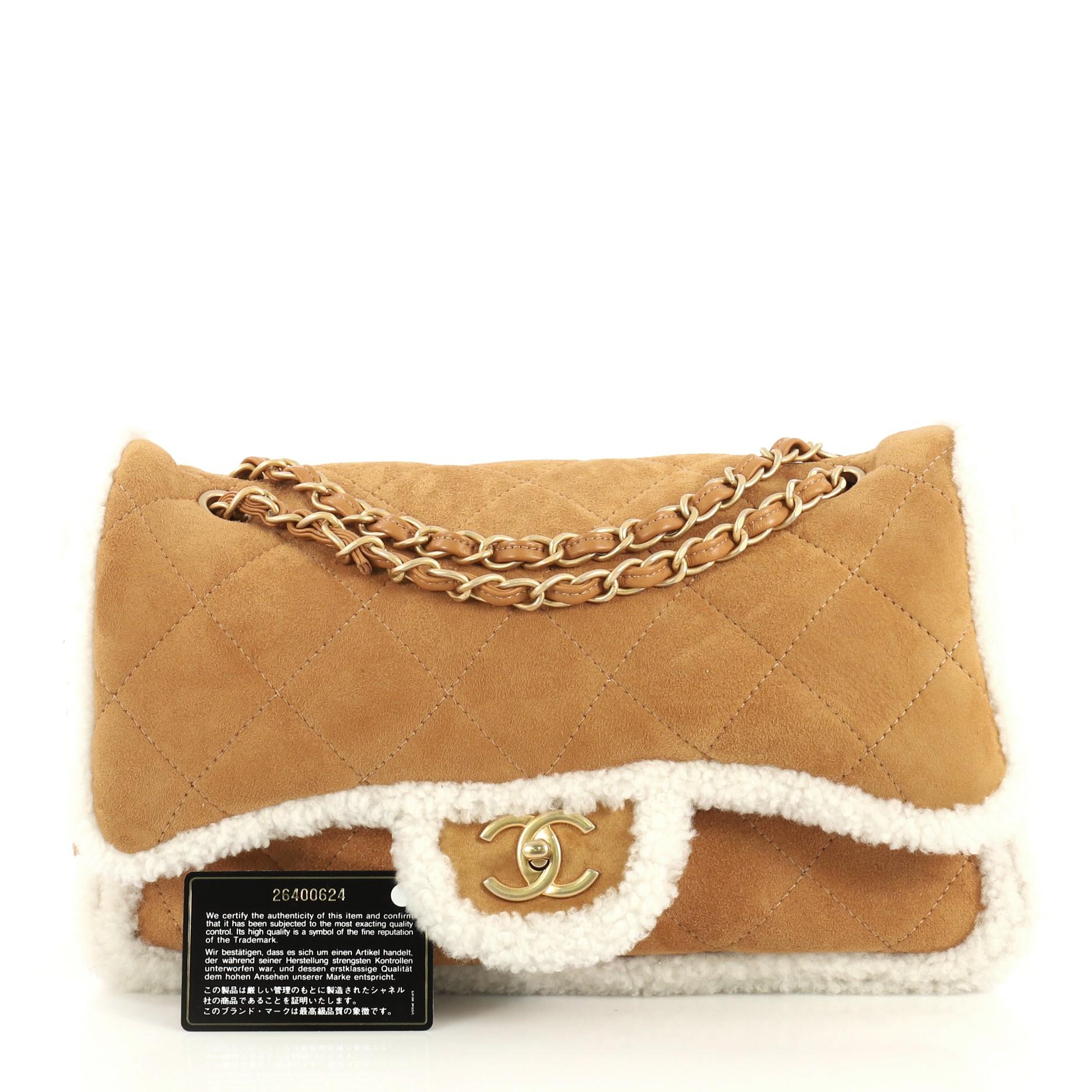 This Chanel Coco Neige Flap Bag Quilted Suede with Shearling Large, crafted in brown and white shearling, features woven-in leather chain link strap and aged gold-tone hardware. Its CC turn-lock closure opens to a brown leather and white shearling