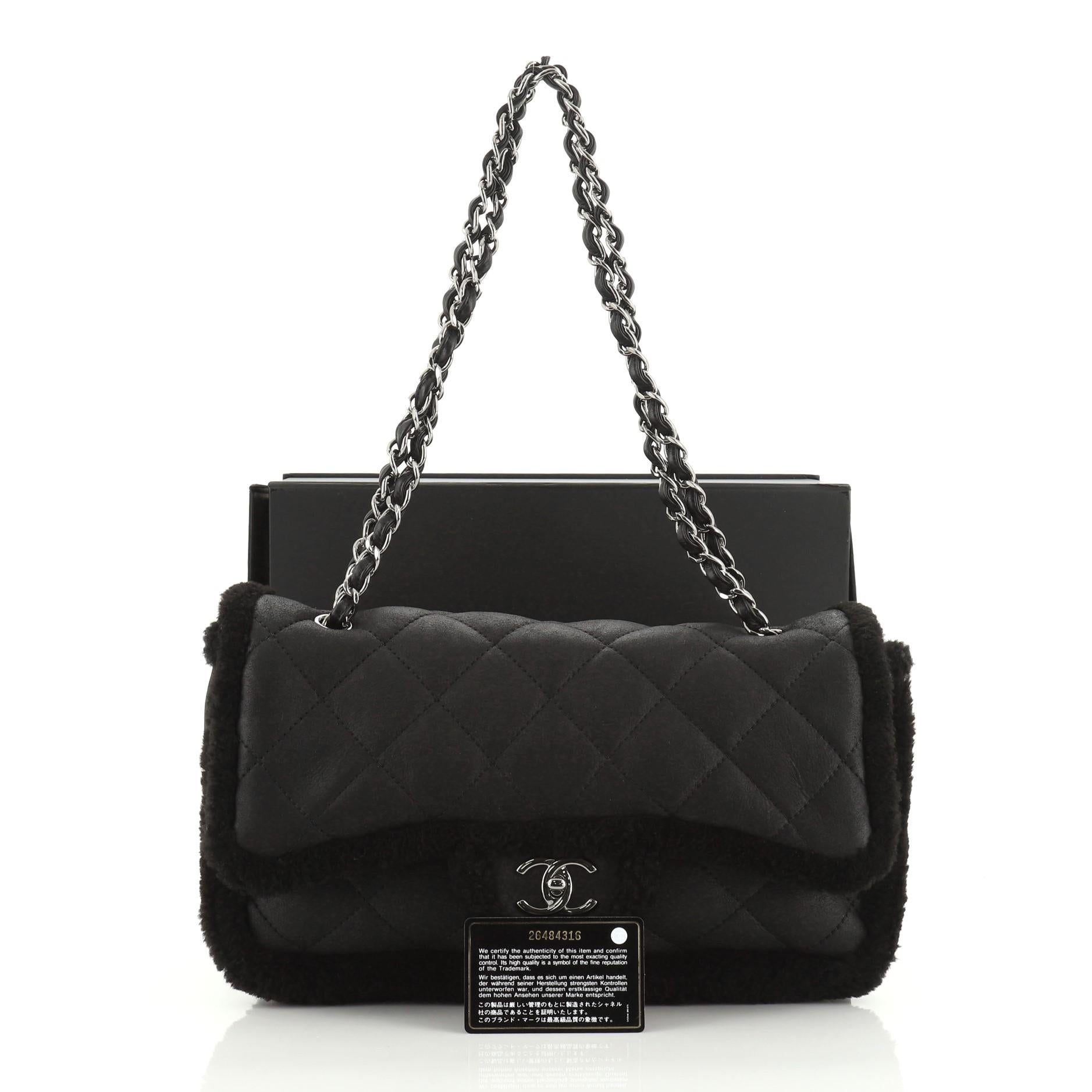 This Chanel Coco Neige Flap Bag Quilted Suede with Shearling Large, crafted in black shearling, features woven-in leather chain link strap and gunmetal-tone hardware. Its CC turn-lock closure opens to a black leather and shearling interior with side