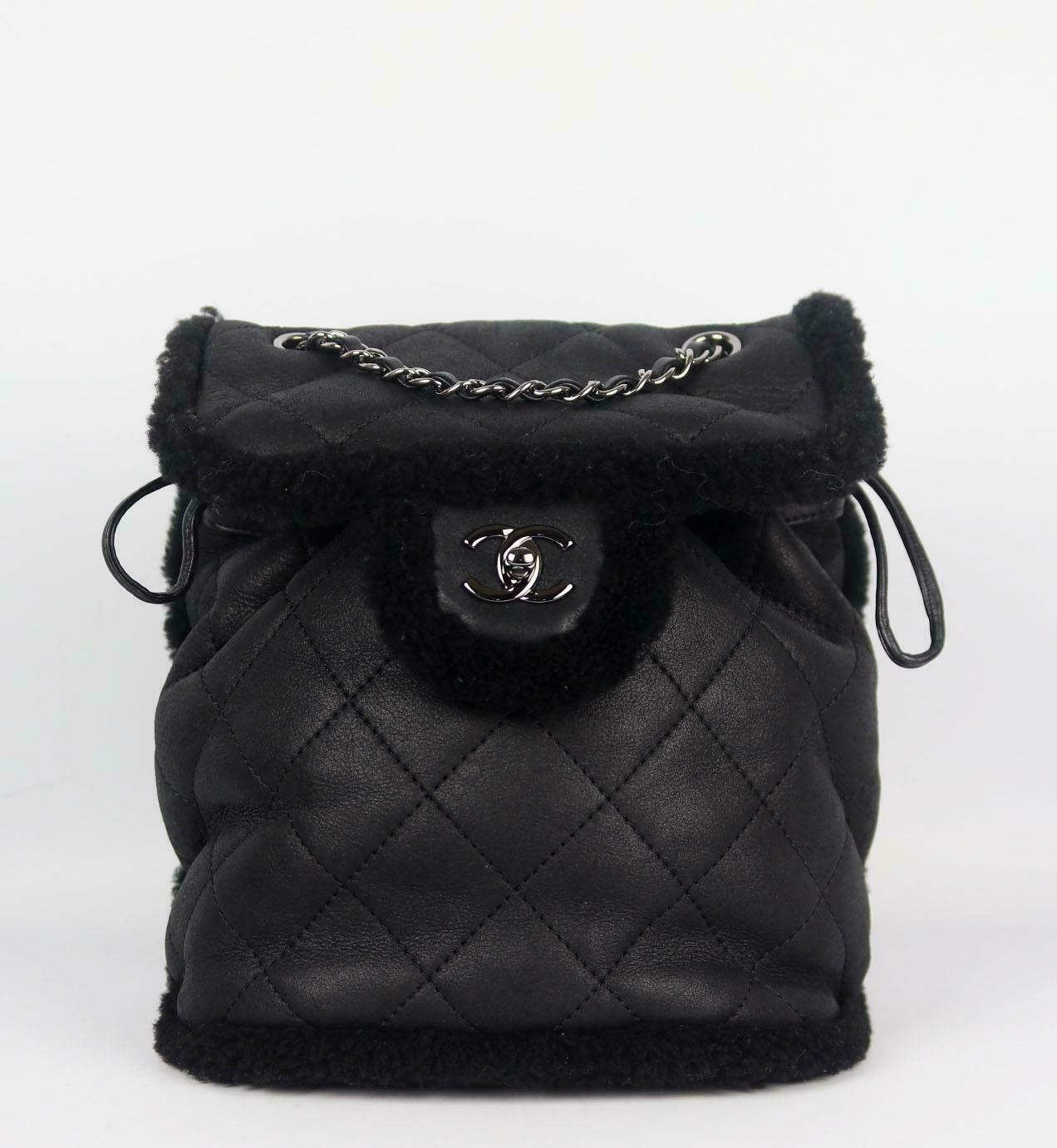 Fabriqué en Italie, ce magnifique sac à dos 'Coco Neige' de Chanel a été réalisé en cuir d'agneau et en shearling noir à l'extérieur et en shearling noir à l'intérieur. Cette pièce est décorée du logo ruthniem-argent de Chanel sur le devant et finie