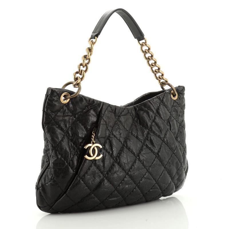 This Chanel Coco Pleats Hobo Quilted Glazed Caviar, crafted in black leather, features chain strap, and aged gold-tone hardware. Its zip closure opens to a purple fabric interior with side zip pocket. Hologram sticker reads: 17250250. 

Estimated