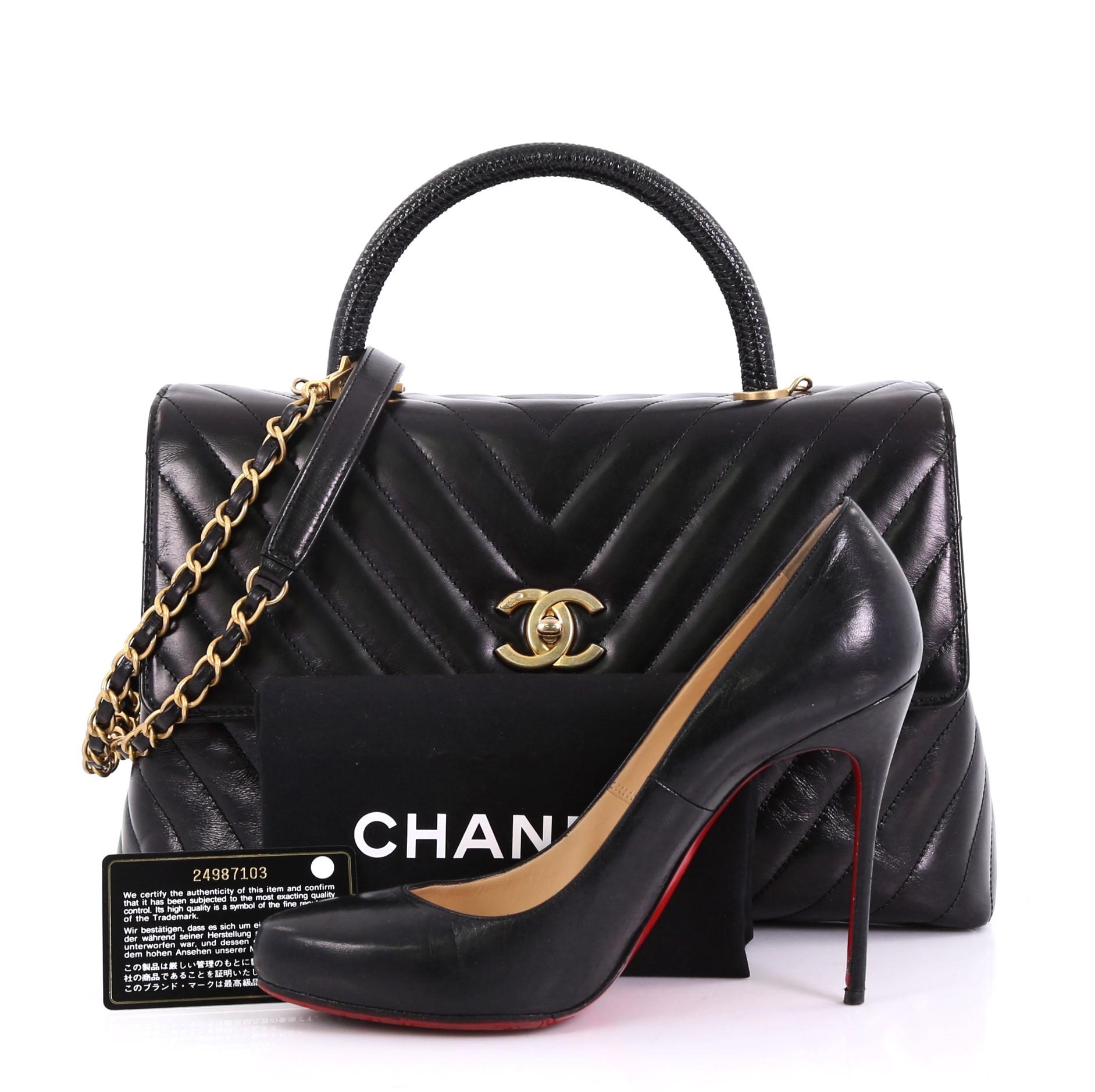 This Chanel Coco Top Handle Bag Chevron Calfskin with Lizard Medium, crafted in black chevron calfskin with genuine lizard, features a rolled top handle, woven-in leather chain link strap with leather pad, exterior back slip pocket, and gold-tone