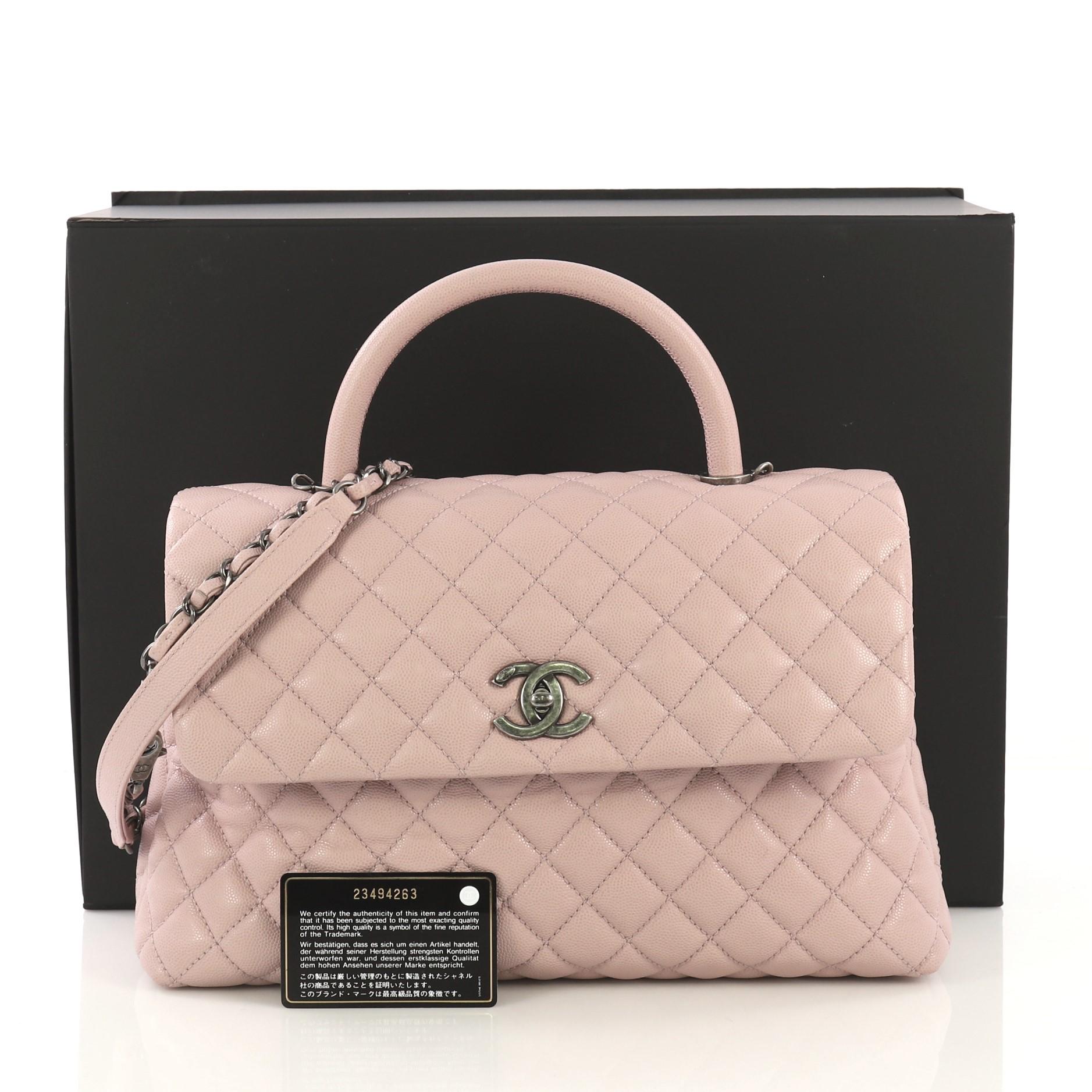 This Chanel Coco Top Handle Bag Quilted Caviar Medium, crafted in pink quilted caviar leather, features single rolled leather top handle, woven in leather chain link strap, exterior back slip pocket, and aged silver-tone hardware. Its CC turn-lock