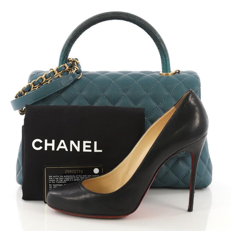 This Chanel Coco Top Handle Bag Quilted Caviar with Lizard Small, crafted in teal quilted caviar with genuine lizard, features a single top handle, woven-in leather chain link strap, exterior back slip pocket, and matte gold-tone hardware. Its CC