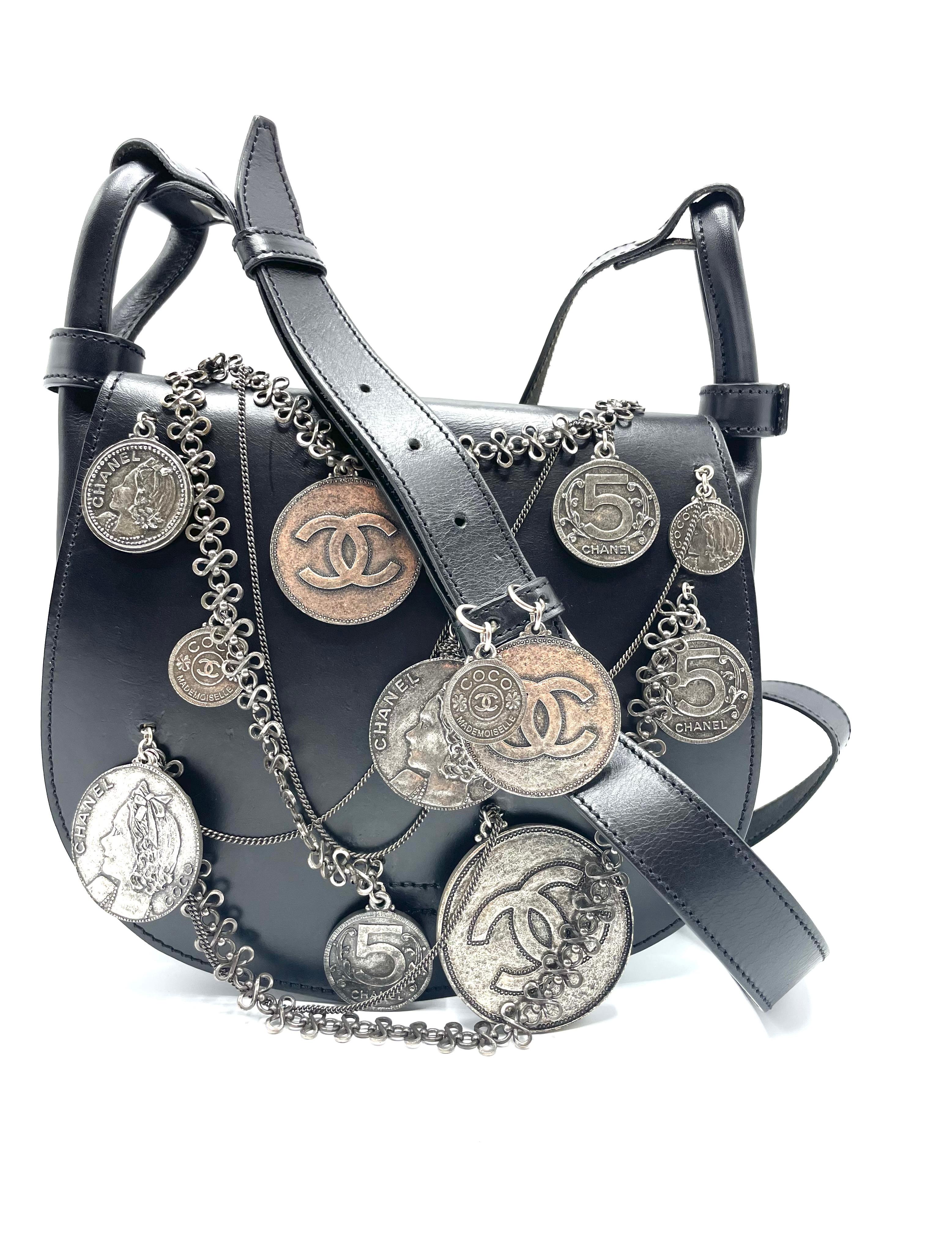 Chanel Coin Medallion Saddle Messenger Leather Small.  A collectible item that is ideal for collectors. This avant-garde saddle bag is crafted from black leather and includes an adjustable leather shoulder strap, overlay chains with Chanel