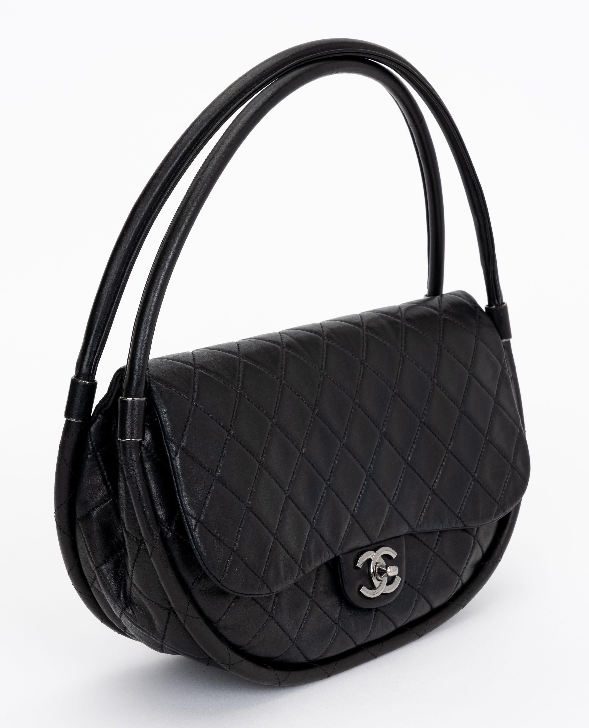 Le Hula Hoop de Chanel, rare et de collection, est fabriqué en cuir matelassé noir et avec des ferrures de couleur argentée. Il est doté d'un rabat avec une fermeture à emboîtement avec le logo CC. 
Collectional 17. Livré avec hologramme, livret,