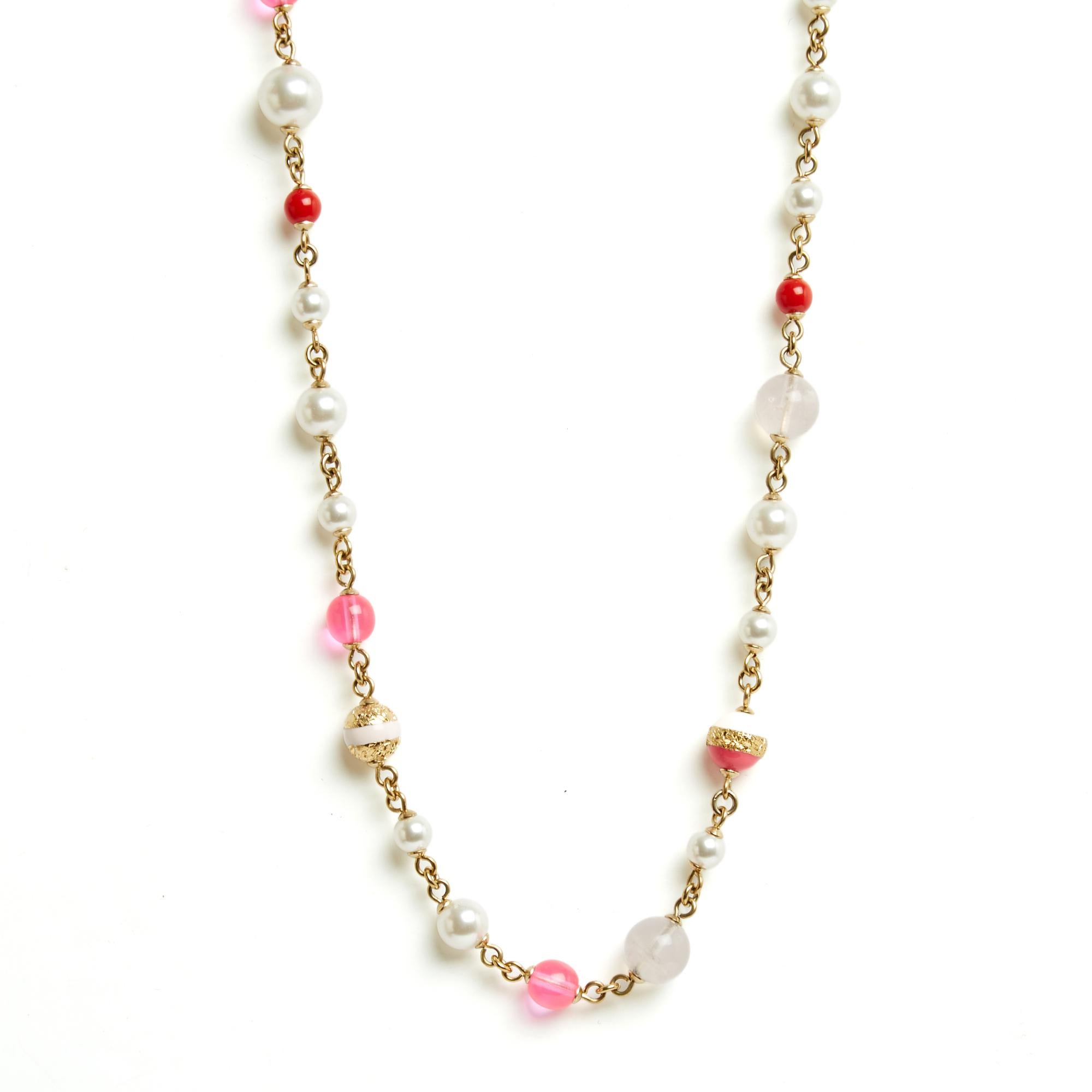 Chanel sautoir necklace in gold-plated metal and white, pale pink and strong pink pearls, and a large CC logo enameled with pink stripes, clasp closure (engraved) on a chain ending with a small CC logo, year 2024. Total length of the necklace