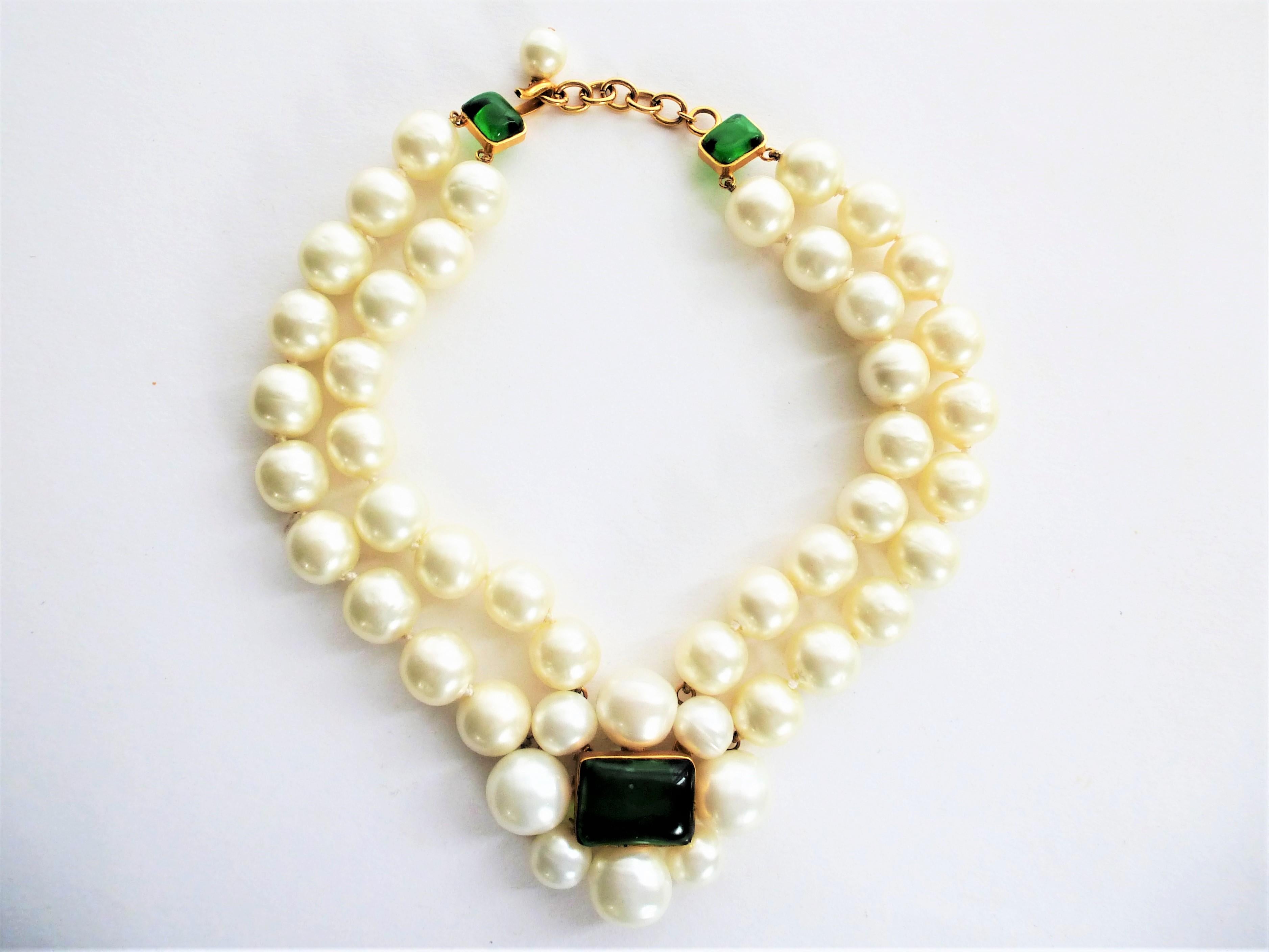Wonderful necklace with very large knotted false pearls. In the middle there is a camellia made of 8 pearls with a green Gripoix glass stone in the middle. As a clasp the same Gripoix in green with hook and eye and 10 cm long extension