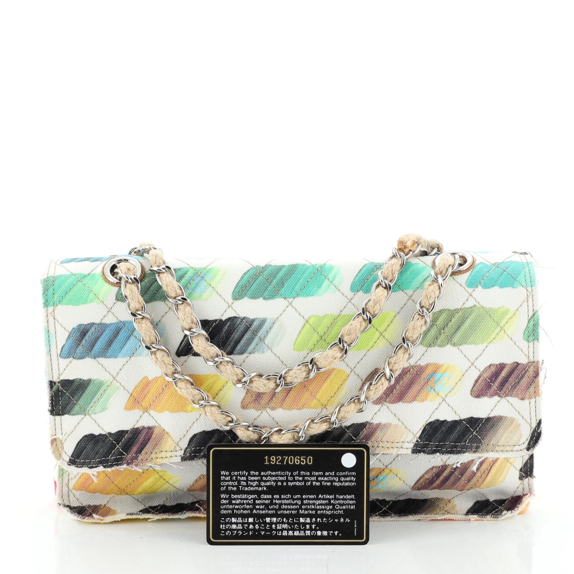 This Chanel Colorama Flap Bag Quilted Watercolor Canvas Medium, crafted in white quilted canvas, features multicolor watercolor brush strokes, exterior back pocket, woven in jute chain link straps and silver-tone hardware. Its CC turn lock closure