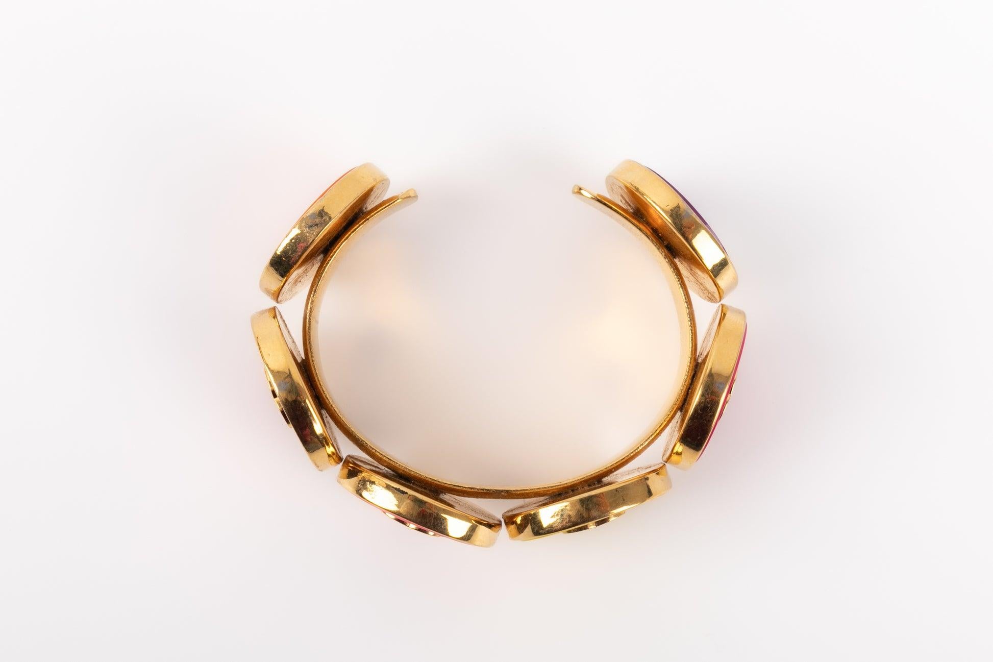 Chanel - (Made in France) Bracciale rigido in metallo dorato ornato da pastiglie di resina colorata sormontate da loghi cc. Collezione 2cc5 dell'inizio degli anni '90.

Informazioni aggiuntive:
Condizioni: Ottime condizioni
Dimensioni: