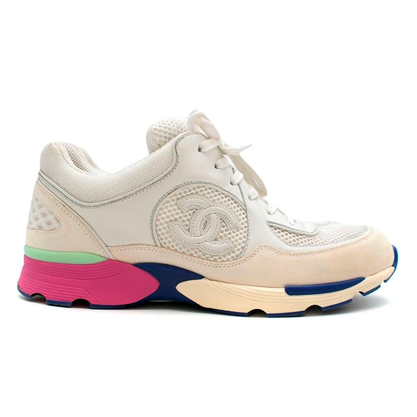 Chanel White Trainers with Colour accents 

- Open knit design 
- White leather and cream suede eyestay heelcounter and heel tab
- Purple, Mint Green and Pink sole 
- Large CC logo on outside of each shoe 
- White laces 

Materials 
- Leather
-