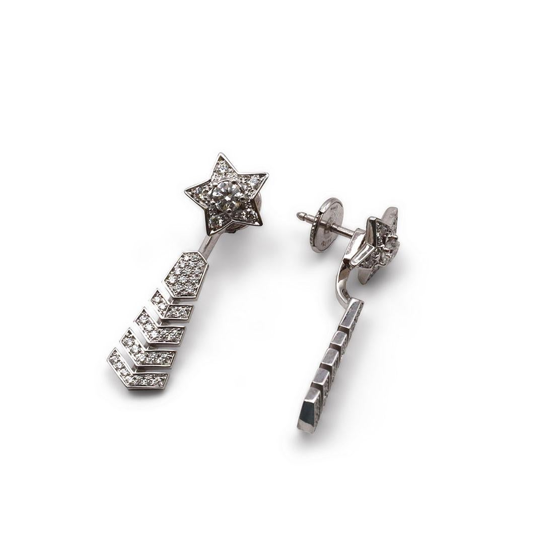 Authentic Chanel Cométe Chevron jacket earrings crafted in 18 karat white gold are comprised of two sections that are removable. The earrings can be worn with the long chevron jacket attached behind the lobe or as simple star ear-studs. These