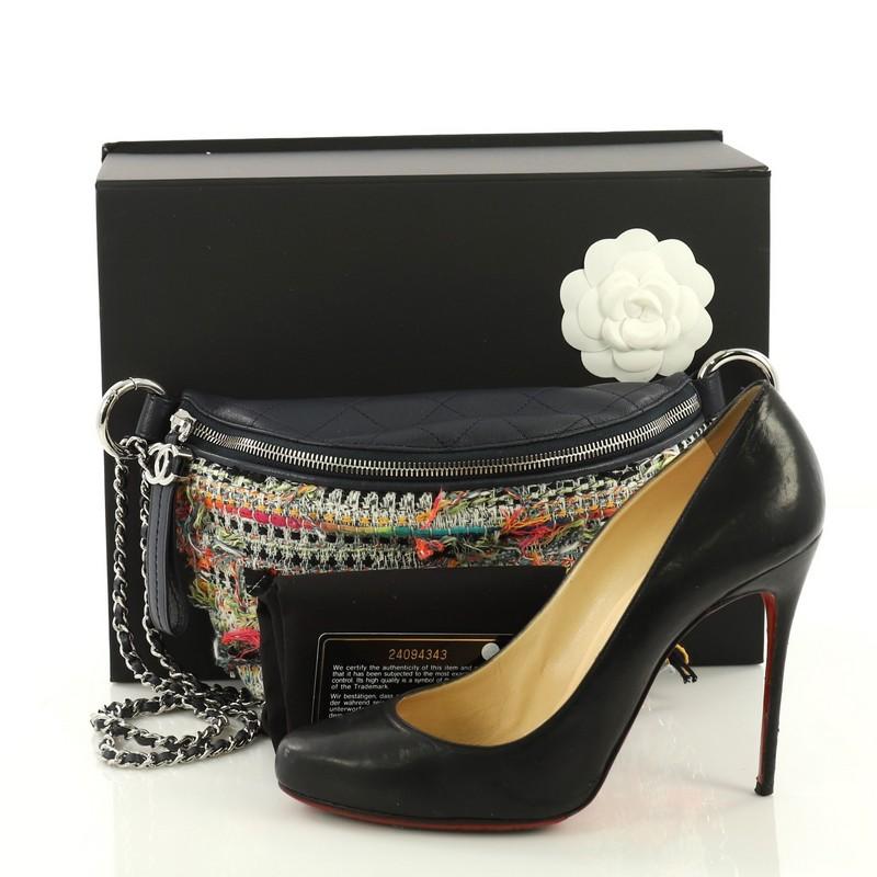 This Chanel Convertible Waist Bag Tweed with Quilted Leather, crafted in multicolor tweed with quilted leather, features woven-in leather chain strap and silver-tone hardware. Its zip closure opens to a navy blue nylon interior. Hologram sticker