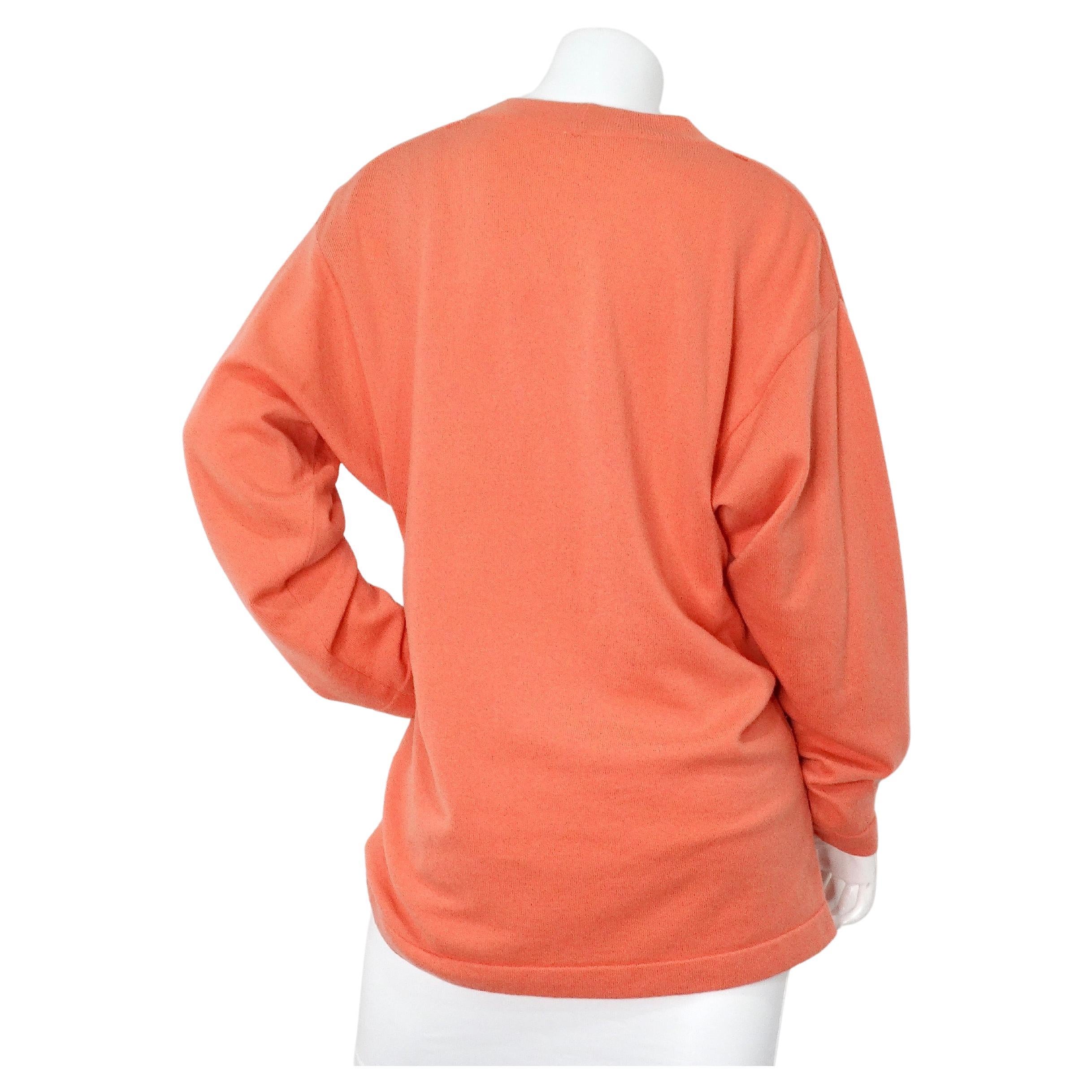 The Chanel Coral Cashmere Cardigan from the 1980s epitomizes timeless elegance and sophisticated craftsmanship. Crafted from luxurious coral-colored cashmere, this vintage piece offers both comfort and refined style. The cardigan features signature