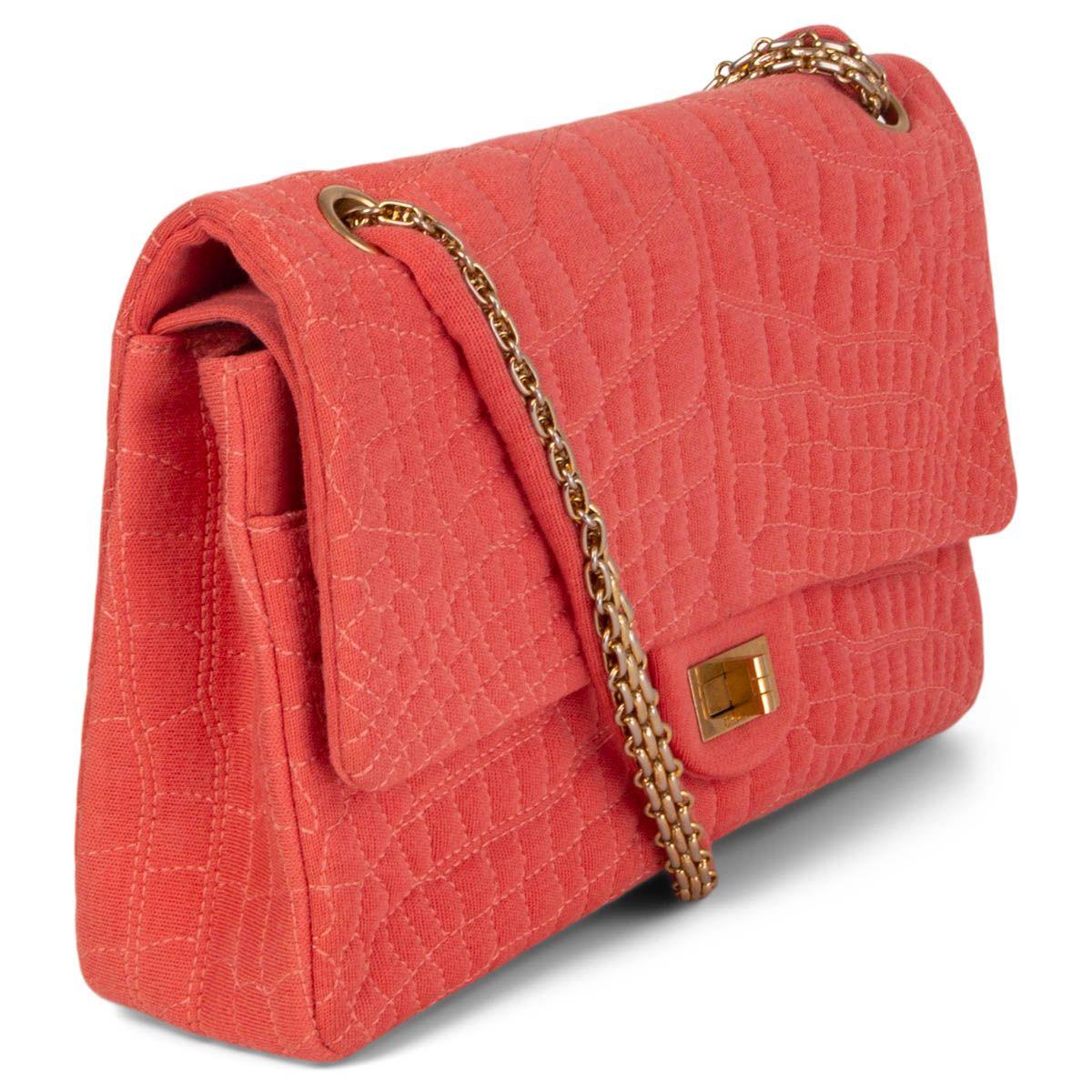 100% authentic Chanel 2.55 Reissue 226 Double Flap Bag in coral croc embroidered jersey fabric and is provided with gold-tone hardware. It features a turn-lock closure and a chain-jersey shoulder strap. Lined in coral nylon fabric with two open