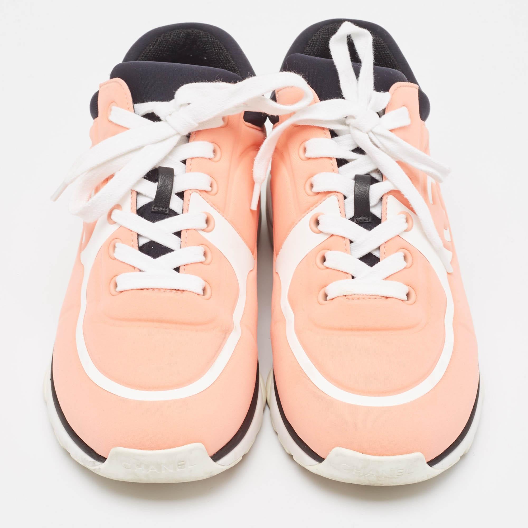 Add a touch of luxury to your casual-sporty look with these amazing Chanel sneakers. Beautifully constructed with neoprene, they feature round toes and the iconic CC logo detailing on the sides. The lace-ups complete this coral pink & white pair