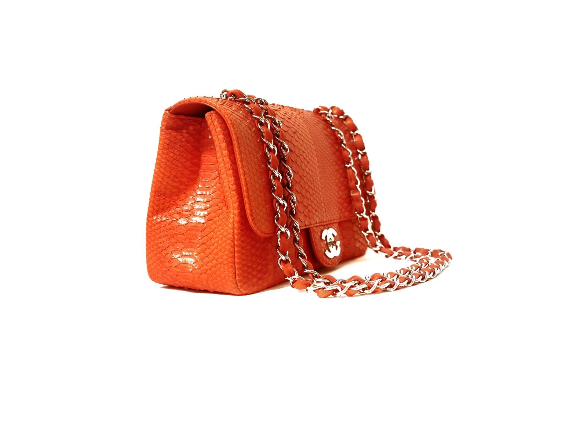 This authentic Chanel Coral Python Jumbo Flap Bag is in pristine condition.  A striking exotic, this is a rare combination in the single flap style. 
Dark coral python skin single flap bag with silver hardware accents.  Silver interlocking CC twist