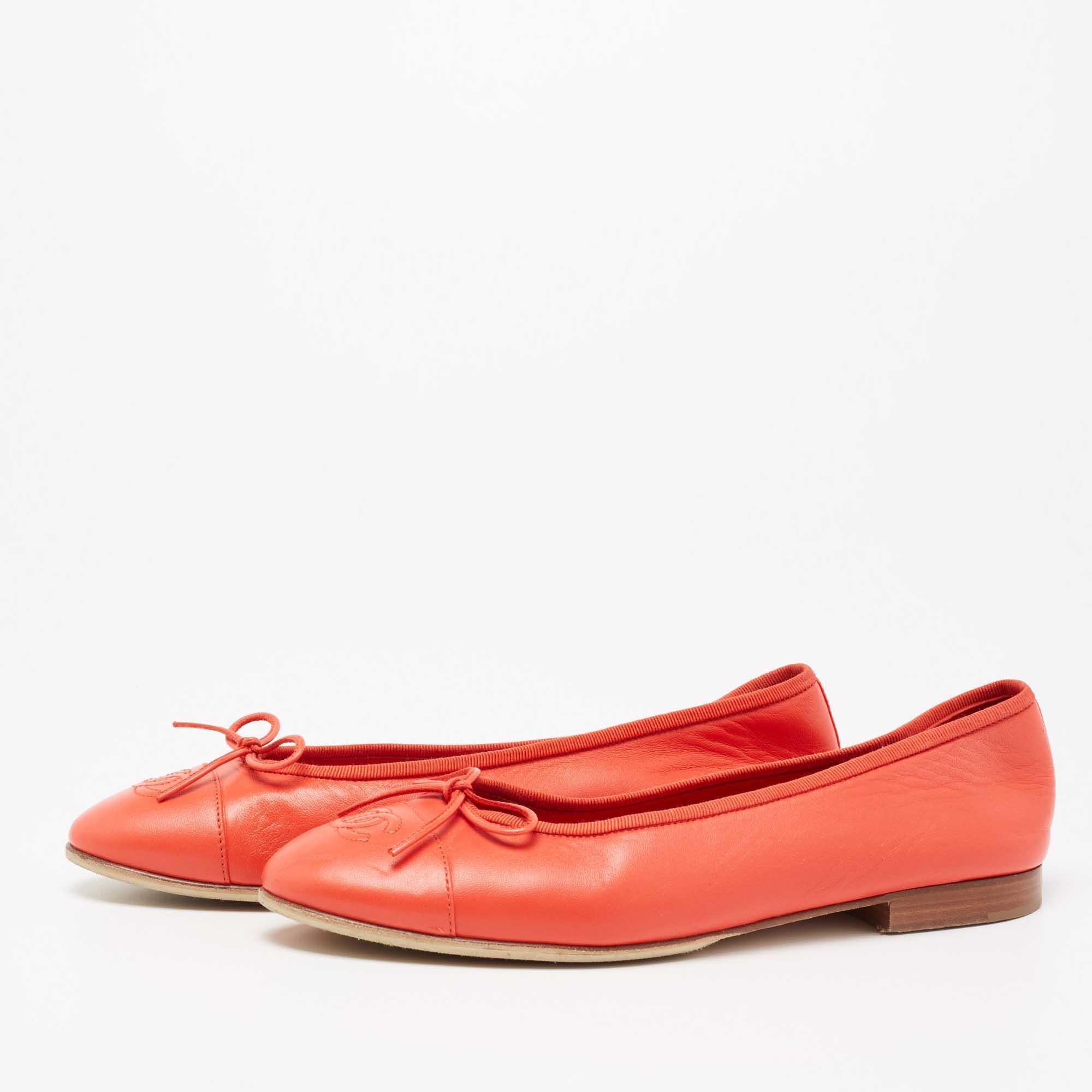 Charming in red and adorned with iconic elements, these ballet flats from Chanel will make you look cuter than ever! Made from coral-red leather, they are embellished with a bow and embossed logo on the cap toes. They are completed in a slip-on