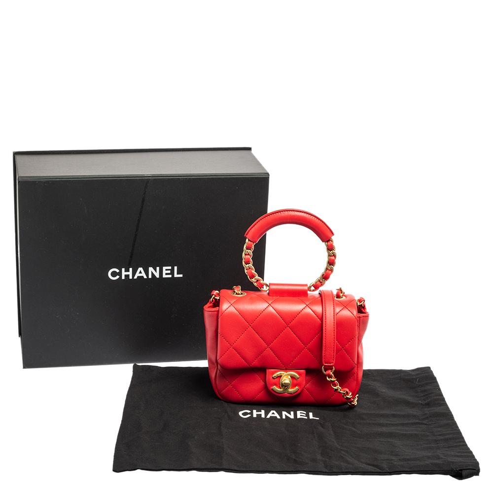 Let Chanel elevate your style with this Chanel top handle bag. A compact, leather-quilted flap bag is paired with a woven shoulder chain and a circular top handle, thus giving you different ways to carry it. It has a fabric interior and gold-tone