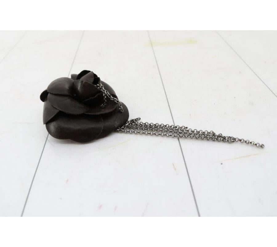 La broche Corsage de Chanel présente une fleur de camélia en cuir de veau noir, des chaînes pendantes de couleur argentée et une fermeture par épingle à nourrice.
 

58987MSC