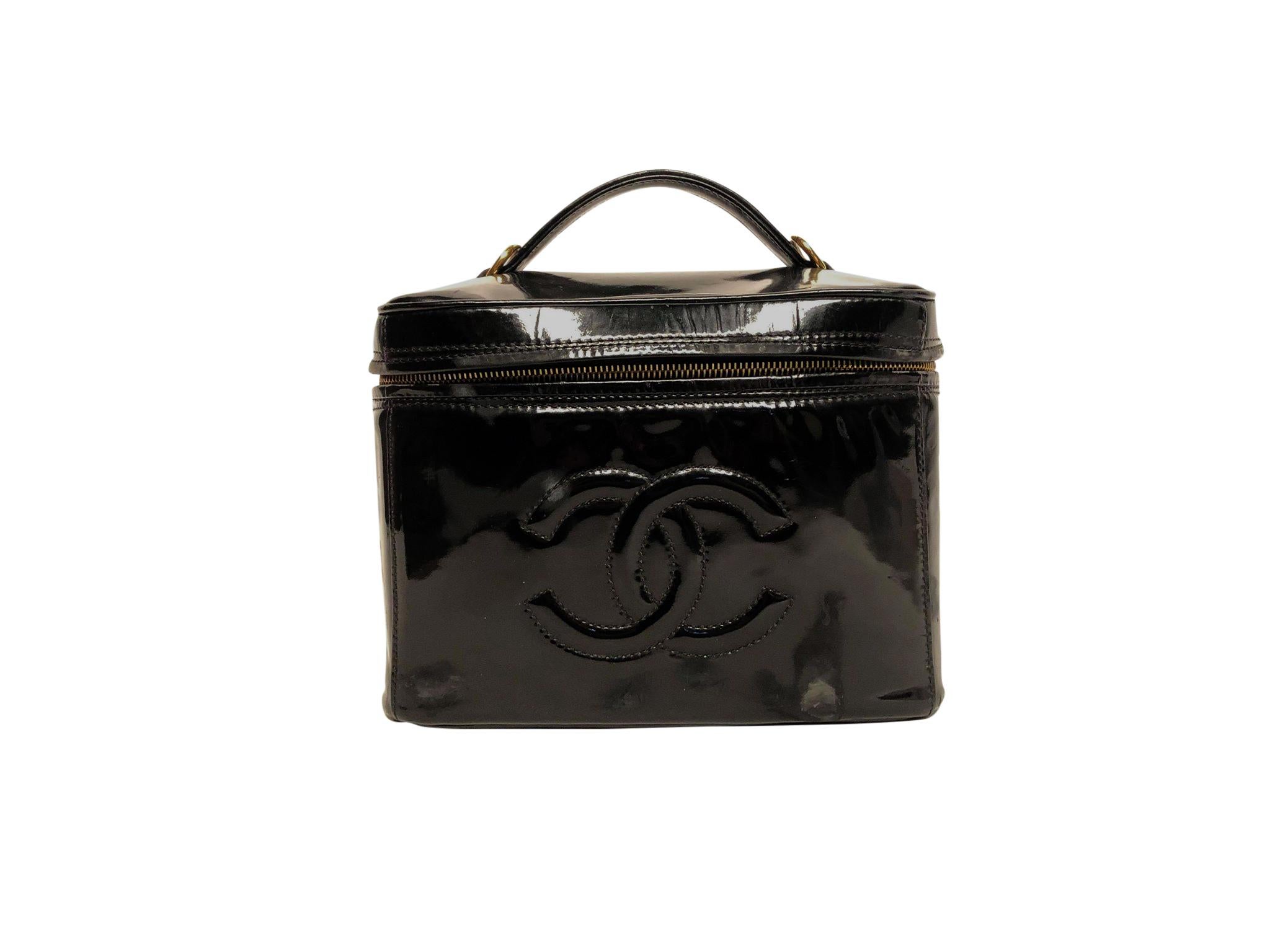 Extremely chic vintage CHANEL patent leather structured makeup case with detachable shoulder strap, top handle and gold toned hardware. This gorgeous cosmetic case features a smooth leather interior and dual wrap around zip opening. This vanity case