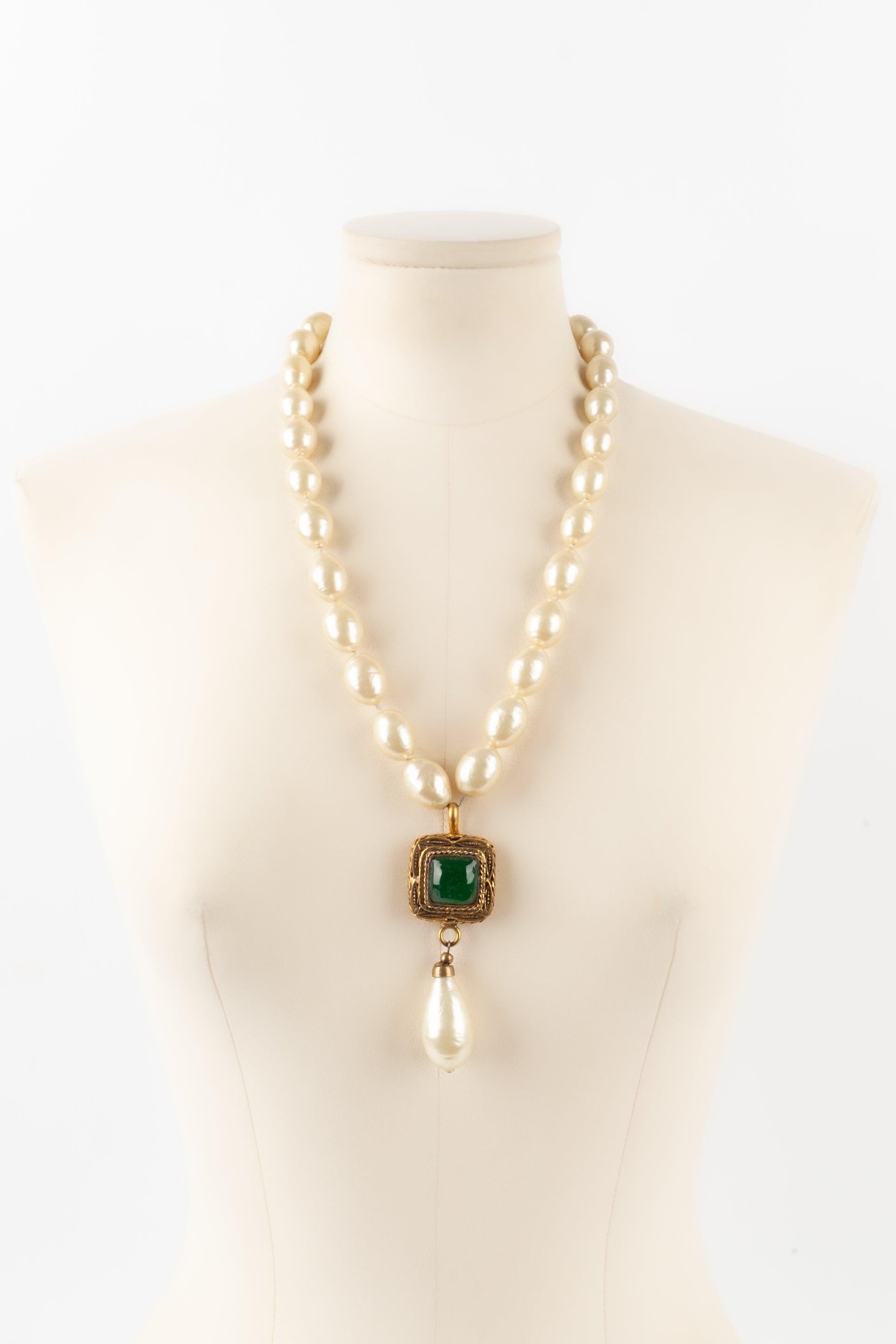 Chanel - Collier de perles fantaisie avec un pendentif en métal doré et une impressionnante goutte nacrée en pâte de verre verte. Collectional 1983.

Informations complémentaires :
Condit : Très bon état.
Dimensions : Longueur : 58 cm à 64
