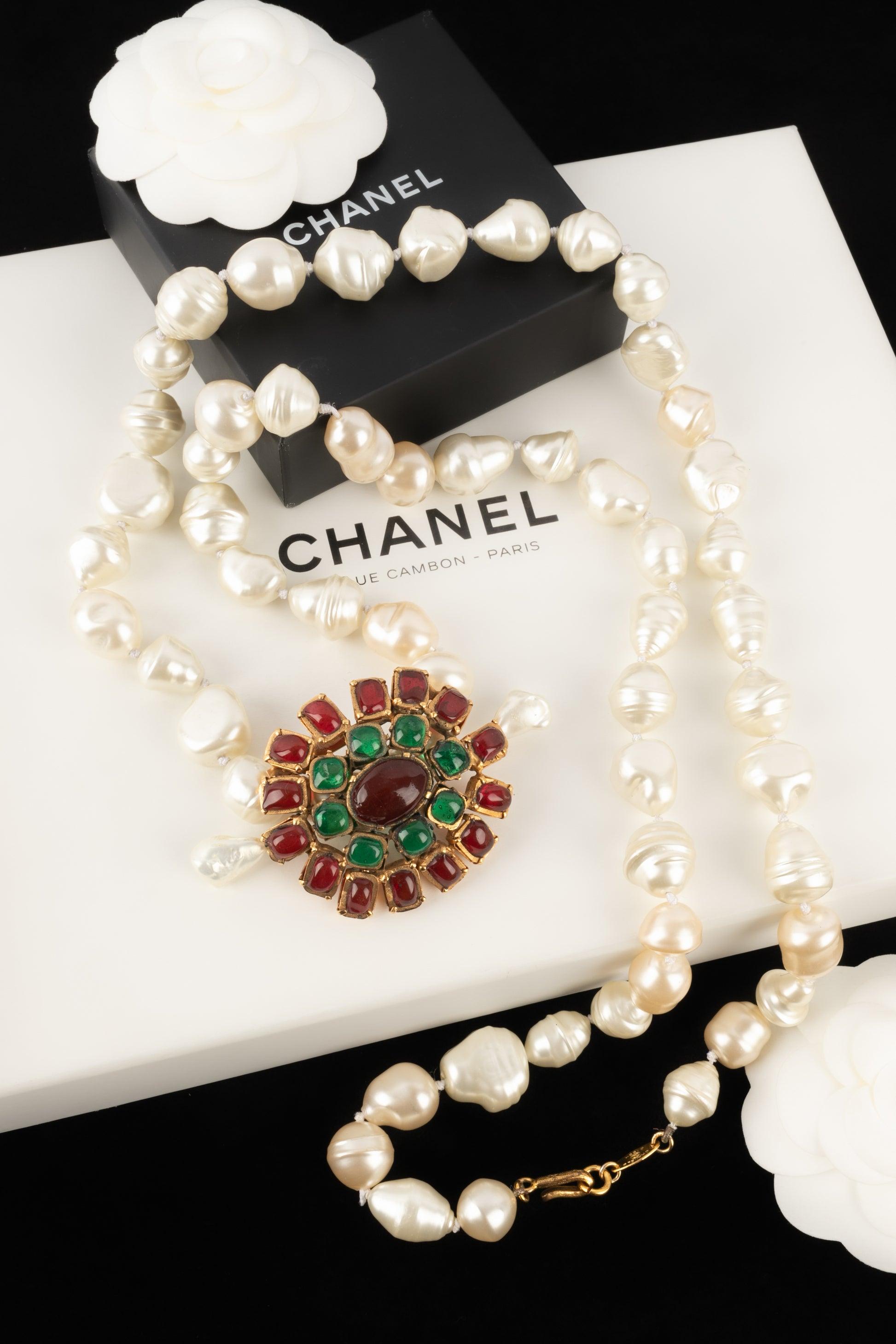 Chanel - (Made in France) Costume pearl necklace holding a golden metal pendant brooch with glass paste. 1984 Collection.

Additional information:
Condition: Good condition
Dimensions: Length: 109 cm
Period: 20th Century

Seller Reference: CB24
