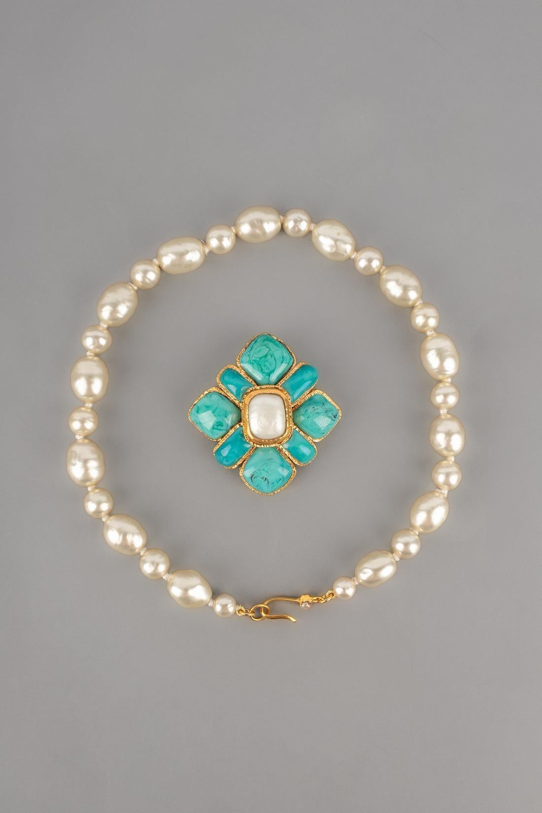 CHANEL - (Made in France) Costume pearl necklace with a golden metal pendant ornamented with turquoise-colour glass paste. Work from the Gripoix atelier for the house of Chanel. 1998 Spring-Summer Collection.

Additional information:
Condition: Very