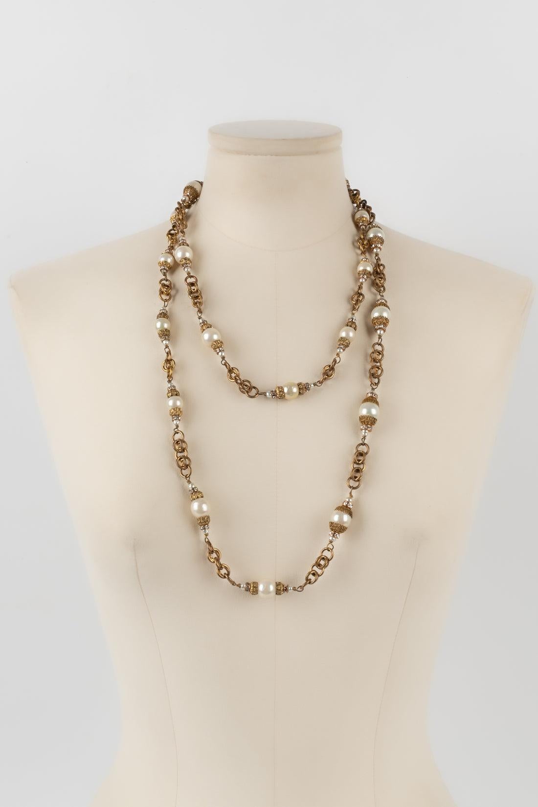 Chanel - (Made in France) Golden metal necklace / sautoir with an old gold color, and with costume pearls. Antique jewelry from the Coco era, i.e. from the 1950s-1960s.

Additional information:
Condition: Good condition
Dimensions: Length: 138
