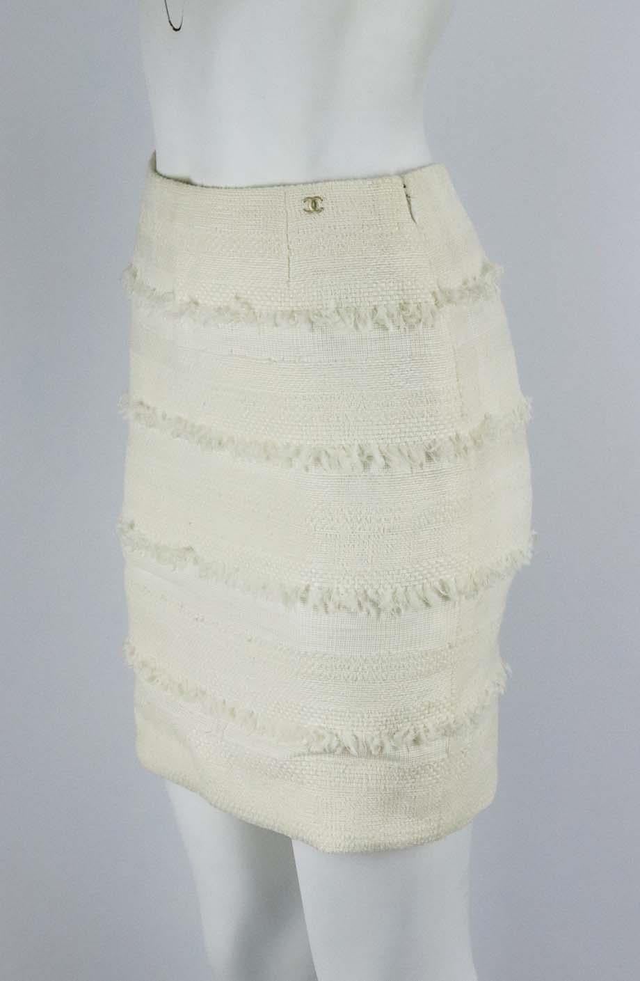 This mini skirt by Chanel encapsulates the tactility of the brand, it is made from slim-fitting cotton-blend tweed with fringing detail throughout. Ivory cotton-blend. Zip fastening at back. 41% Cotton, 40% nylon, 19% wool. Size: FR 34 (UK 6, US 2,