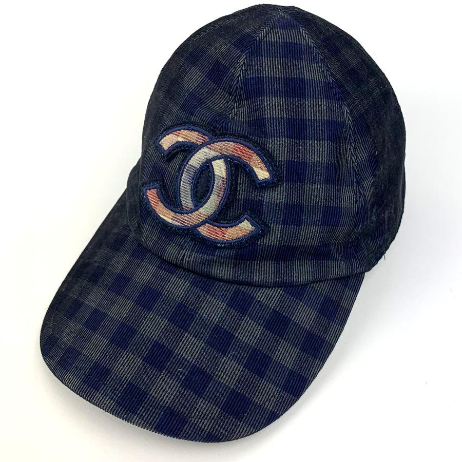 The cap is from Maison CHANEL. It has a blue and gray plaid pattern and features above the edge of the mark, the CC emblem of the brand in shades of red.
The cap is in very good condition. It corresponds to a size S. It is made of 100% cotton and it