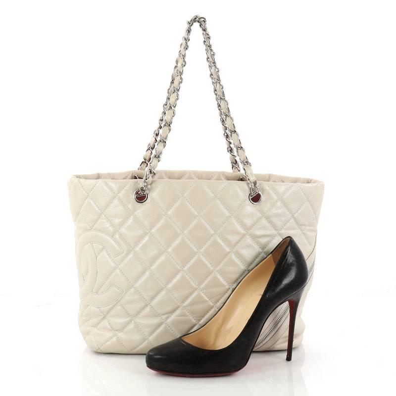 This authentic Chanel Cotton Club Tote Quilted Aged Calfskin Large will add some glam to your everyday look. Crafted in beige quilted aged calfskin leather, this stylish bag features dual woven-in leather chain straps, exterior back slip pockets,