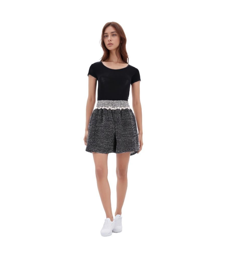 Chanel Cotton Tweed Shorts

High-waisted shorts crafted in black and white tweed with raw-trimmed light grey elasticated waistband.

Detailed with round silver 'CC' logo plaque to the side; lined with silk.

Size – 34FR

Condition – Very
