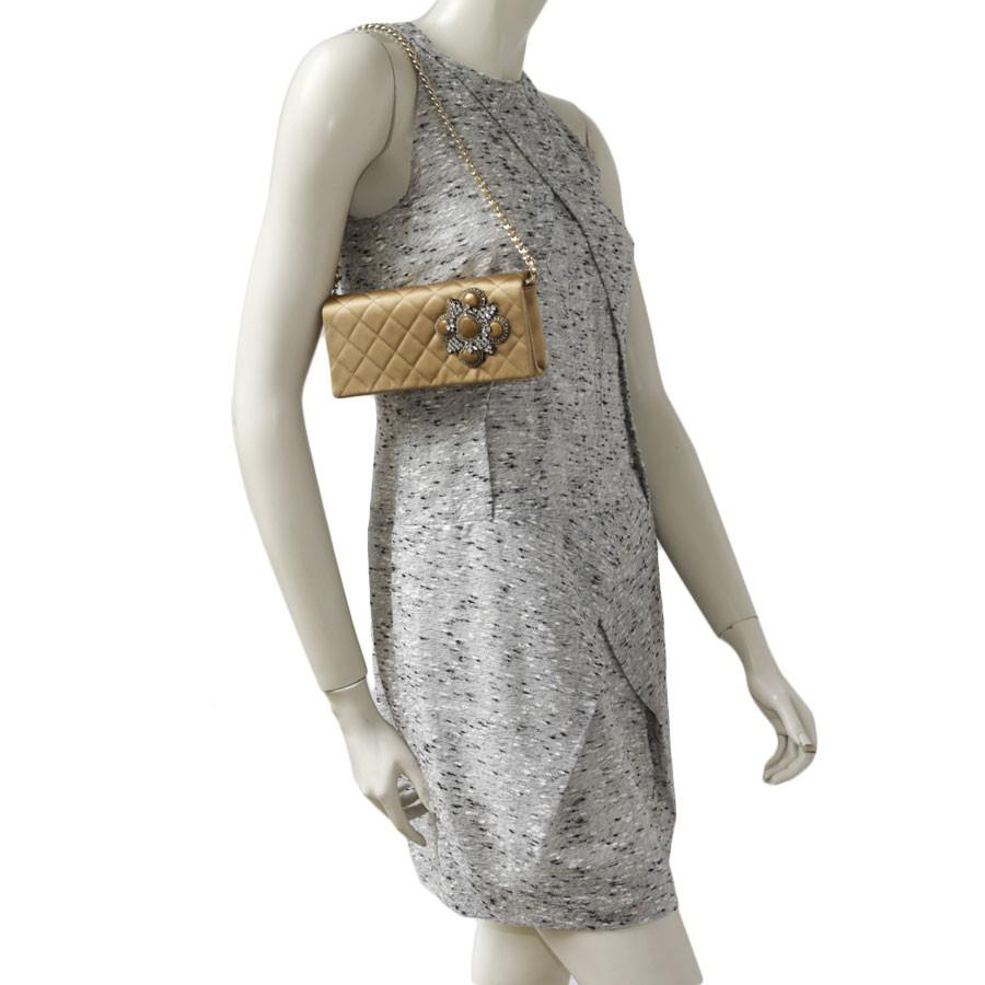CHANEL Couture evening bag in silk satin:
This CHANEL evening clutch is in gold silk satin. The hardware is in gold metal. 
Worn by hand as a clutch or on the shoulder using a gold chain and gold leather shoulder strap. 
The lining is in silk satin
