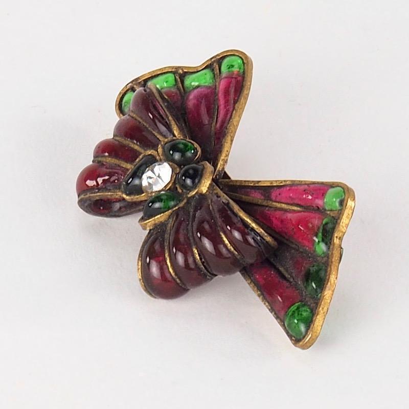 A beautiful and rare Chanel Couture ruby and emerald poured glass brooch bound in brass, created by Maison Gripoix.