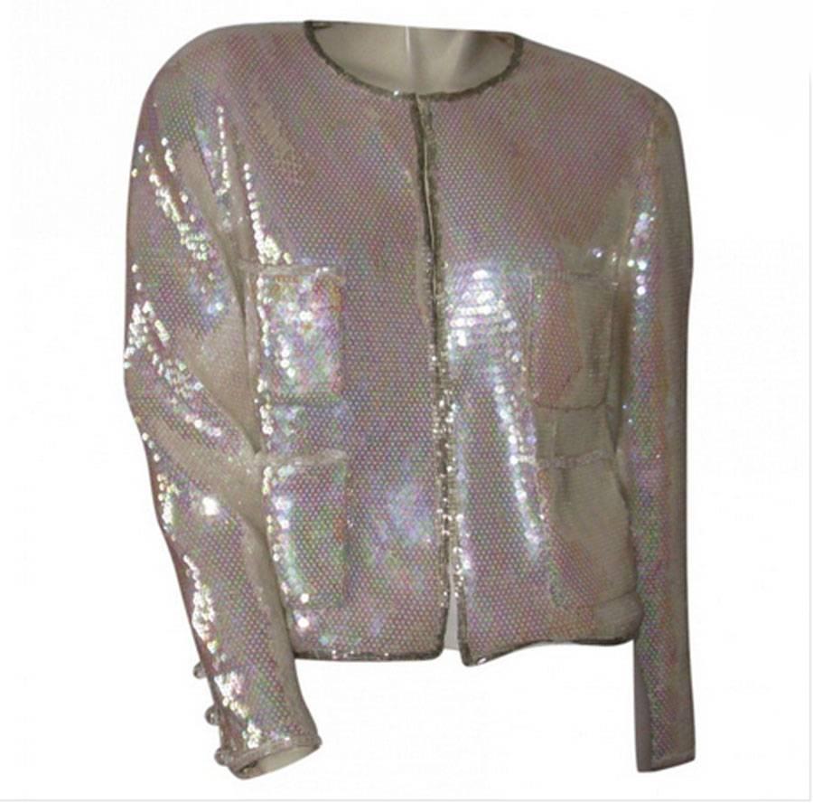 Sublime! Chanel couture jacket in pearly white sequin. It has a round neck, long sleeves, with 4 front patch pockets. 

Very discreet wrist closure with 3 snap buttons and 3 beautiful transparent beveled beads on the sleeves.

The collar, the front