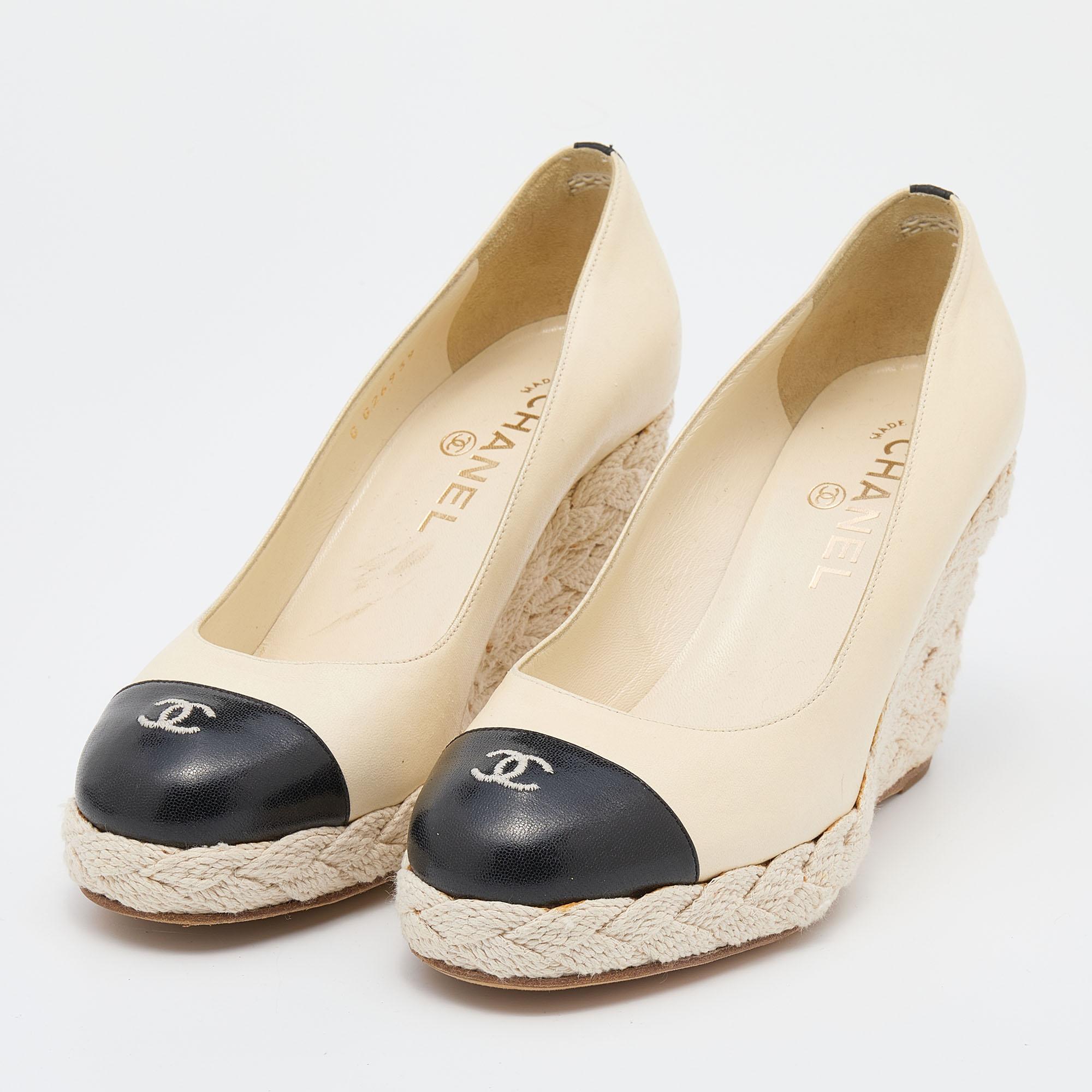 The usage of black and cream shade offers this pair of Chanel pumps an elegant contrast. Constructed from leather, it features espadrille trims, a 'CC' motif on the cap toes, and wedge heels.