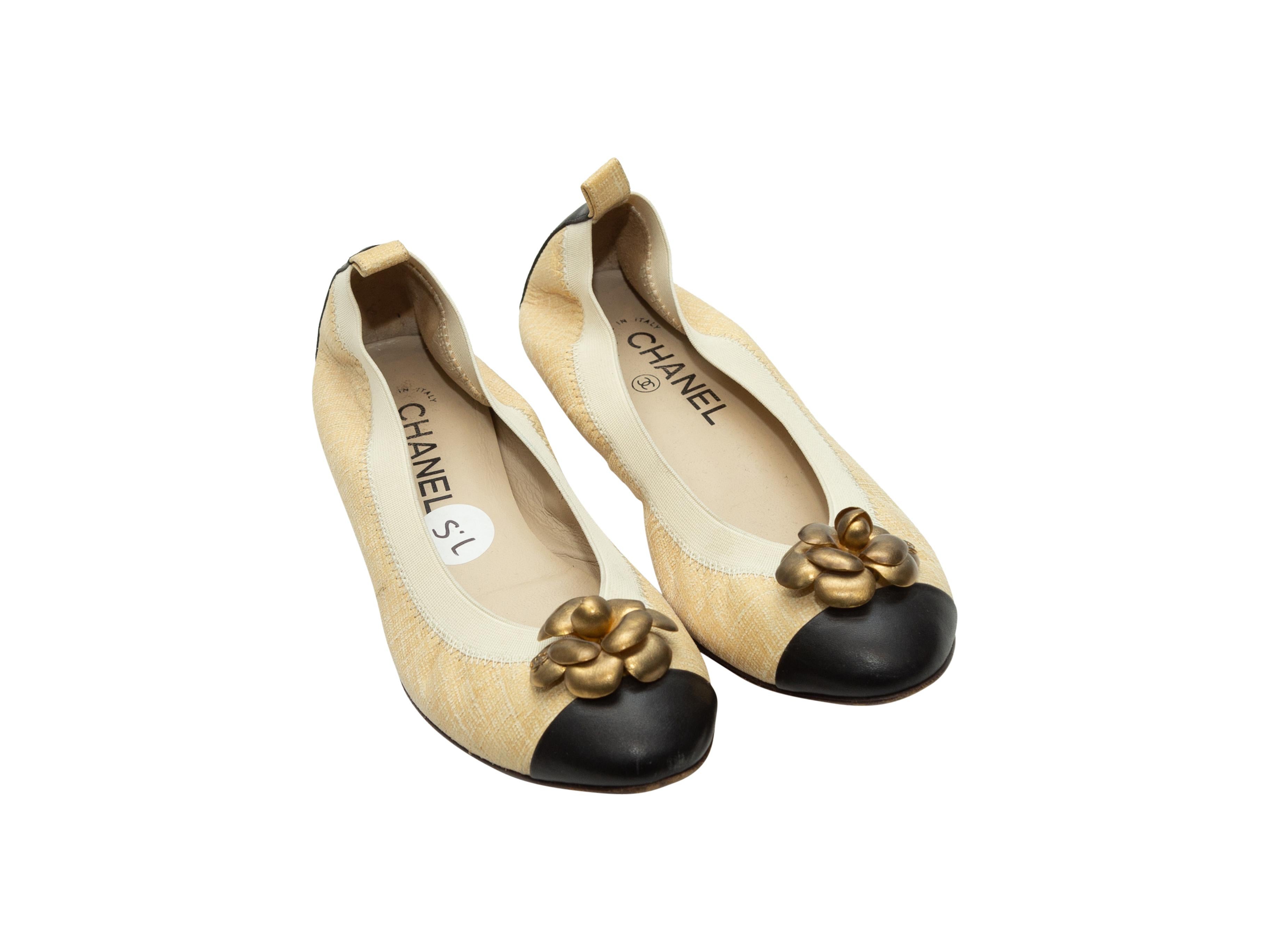 Product details:  Cream and black tweed ballet flats by Chanel.  Elasticized top line for a comfy fit.  Flower charm accents vamp.  Round cap toe.  Goldtone hardware.  
Condition: Pre-owned. Very good.