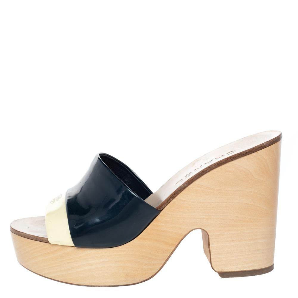 Flaunt your love for fashion when you wear these clogs from Chanel. Look your casual best as you step out in these stylish sandals crafted in Italy and made from quality patent leather. They come in cream & blue hues and feature open toes. They are
